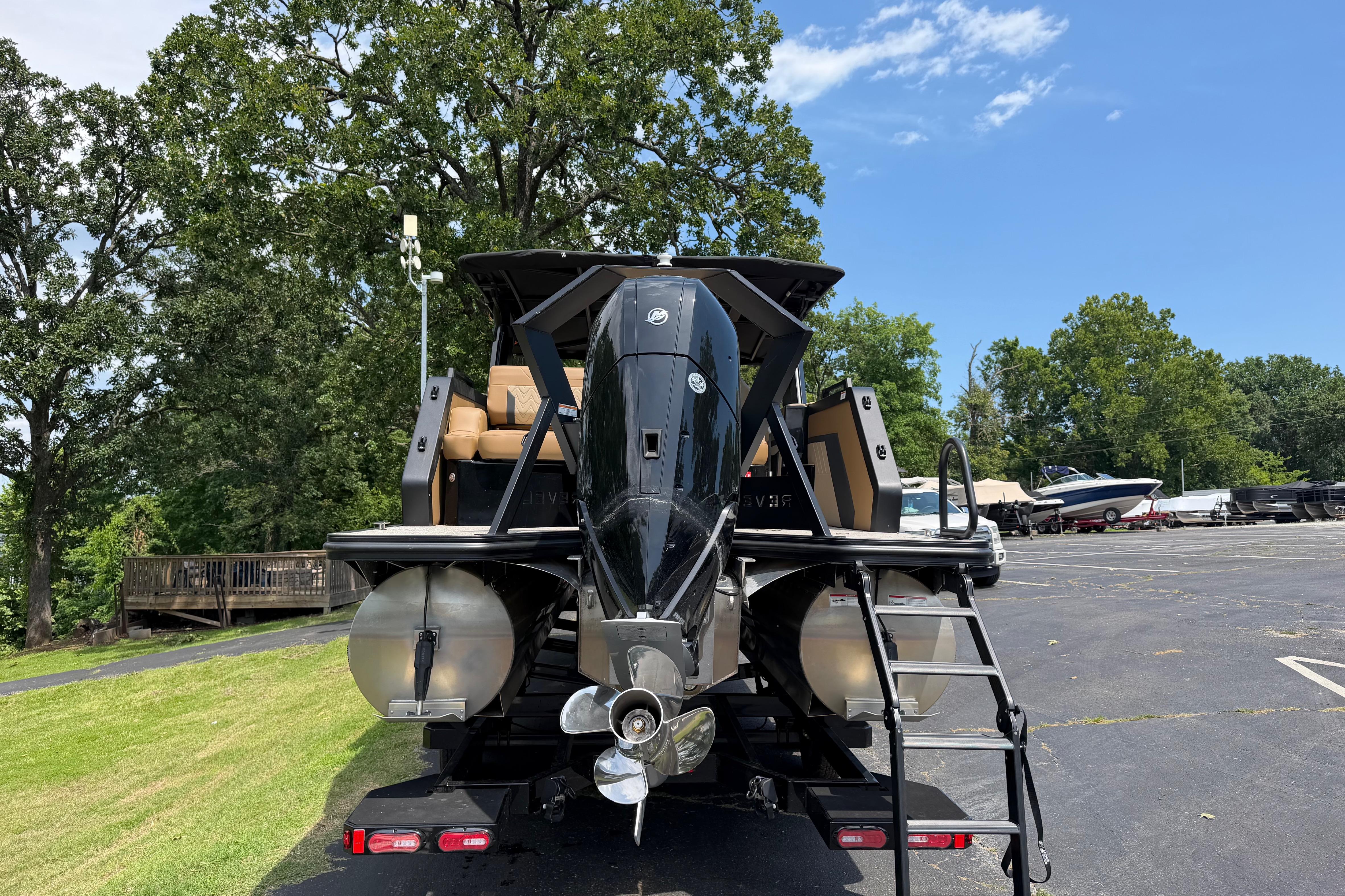 2026 Revel RS25L boat on trailer, parked outdoors with trees in background.