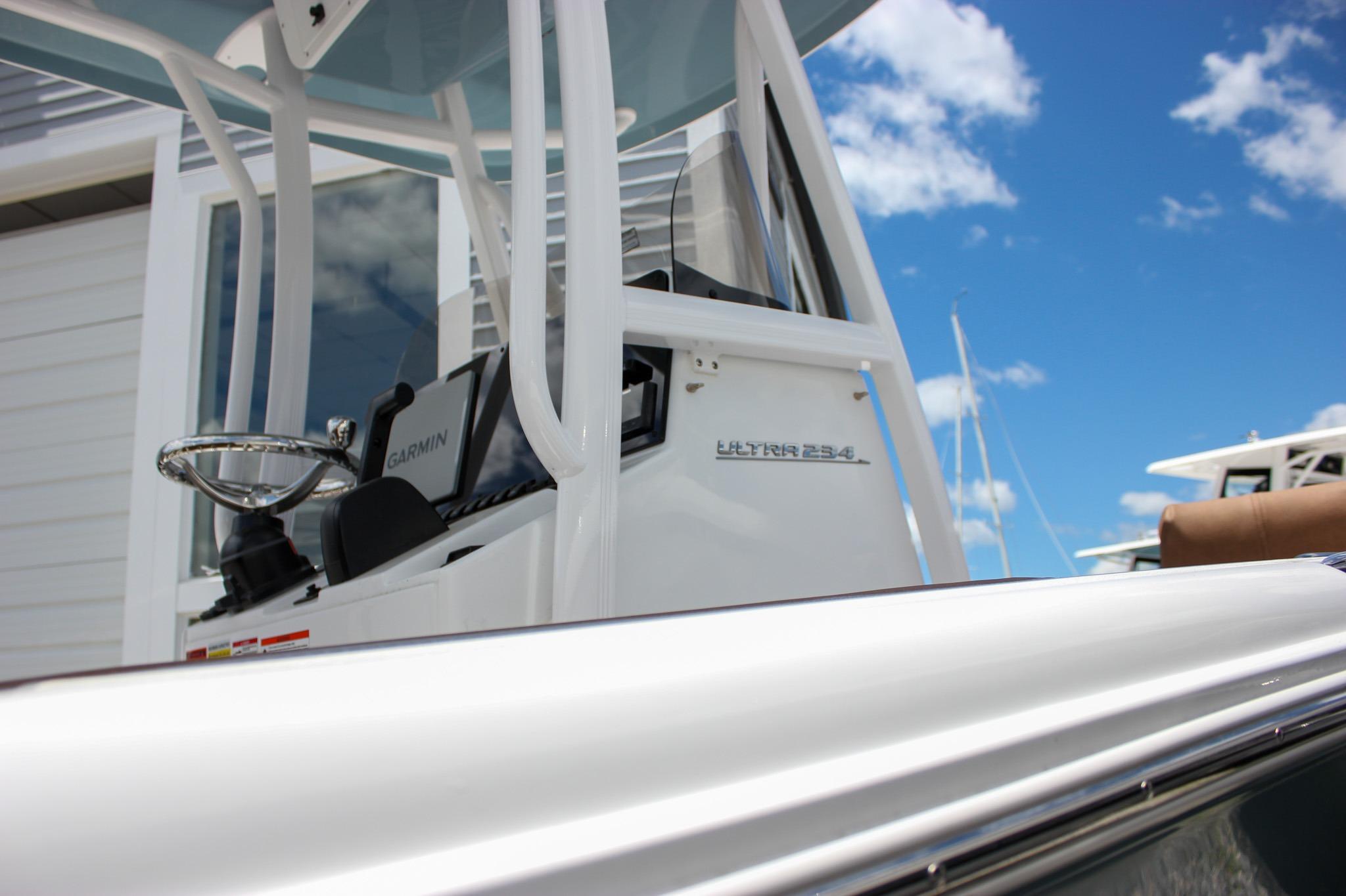 2027 Sea Hunt Ultra 234 boat console with Garmin navigation, under clear blue sky.