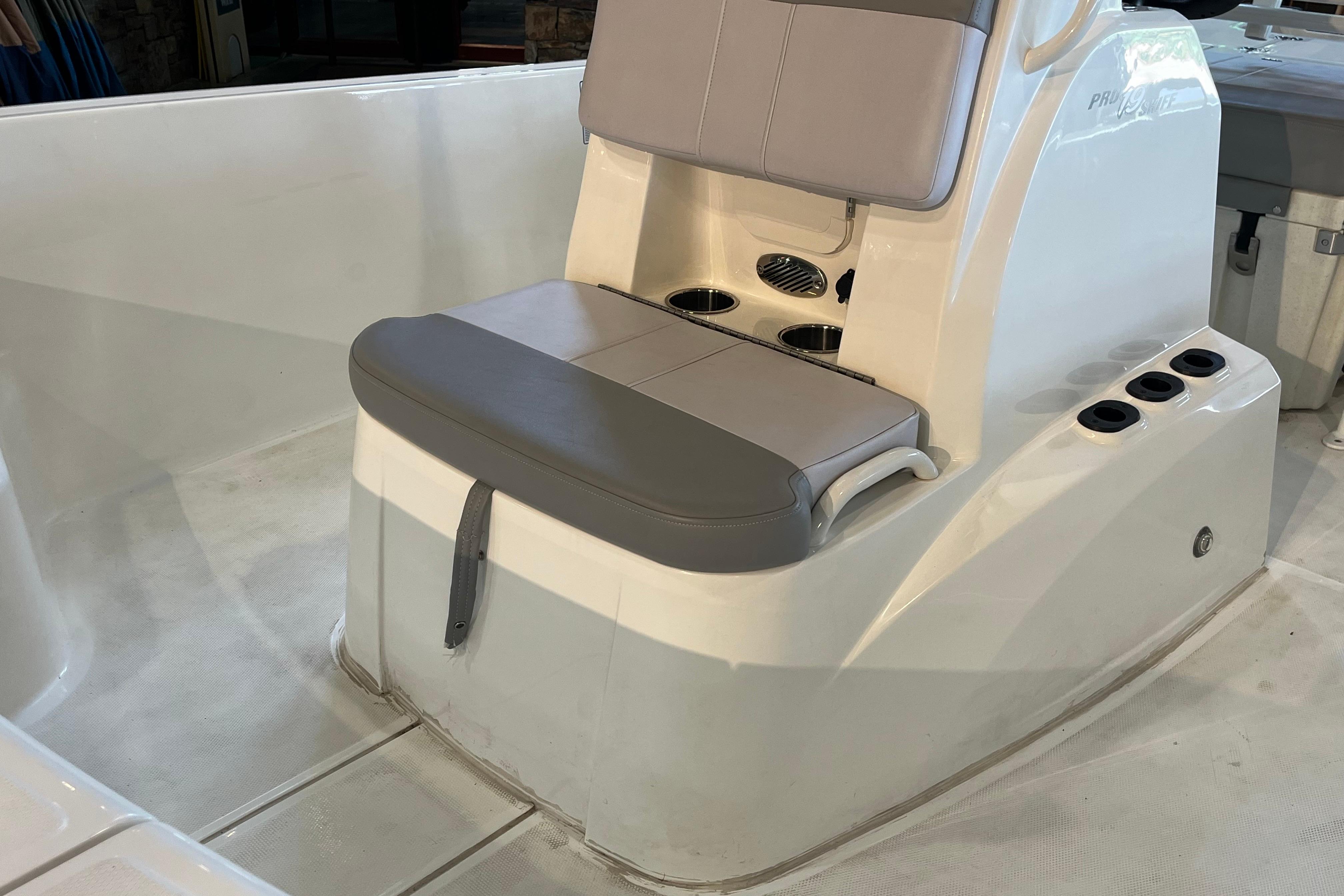 2024 Mako Pro Skiff 19 CC boat interior with cushioned seating and cup holders.
