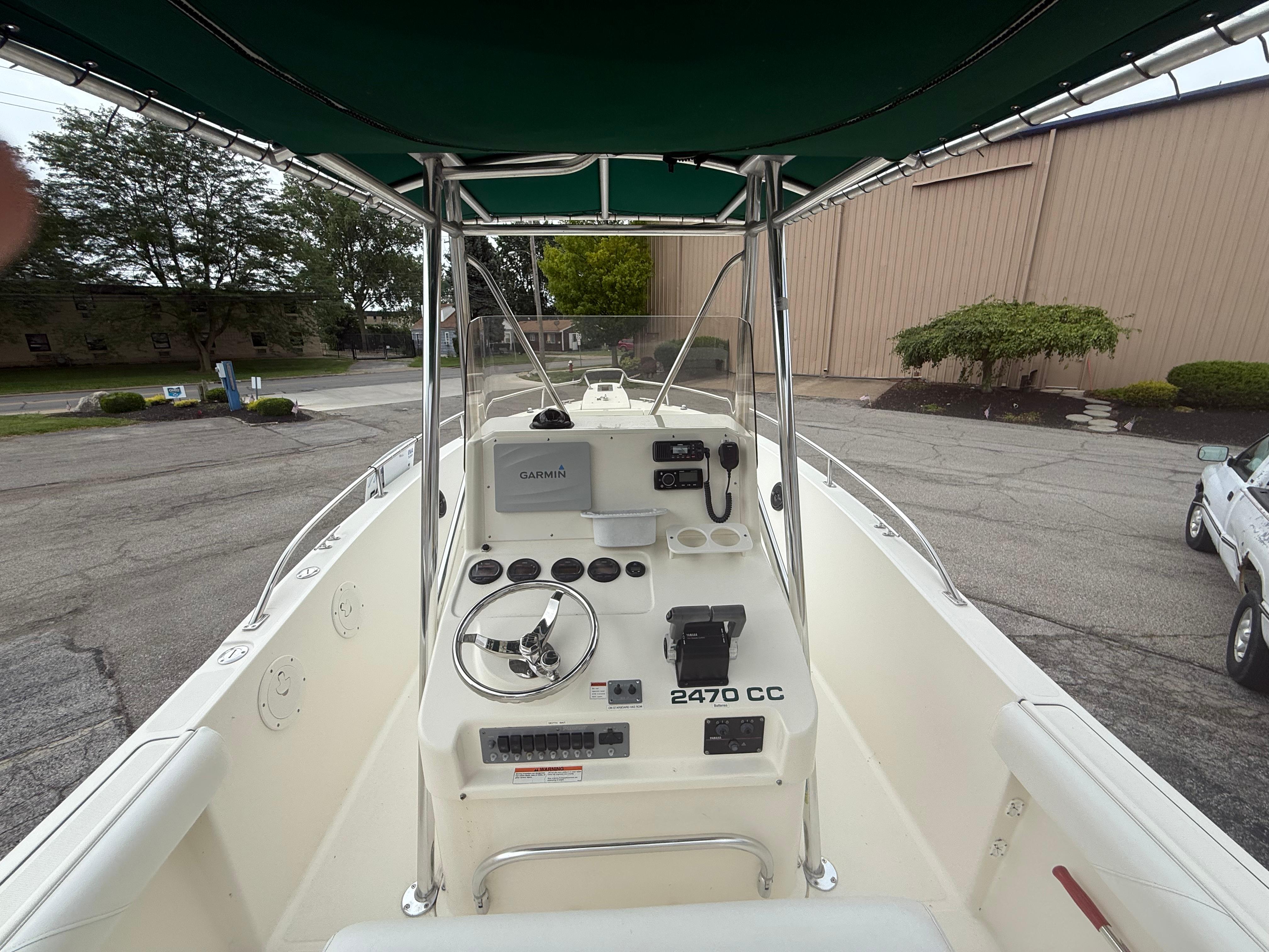 2002 Pursuit 2470 CC boat cockpit with steering wheel and Garmin navigation system.