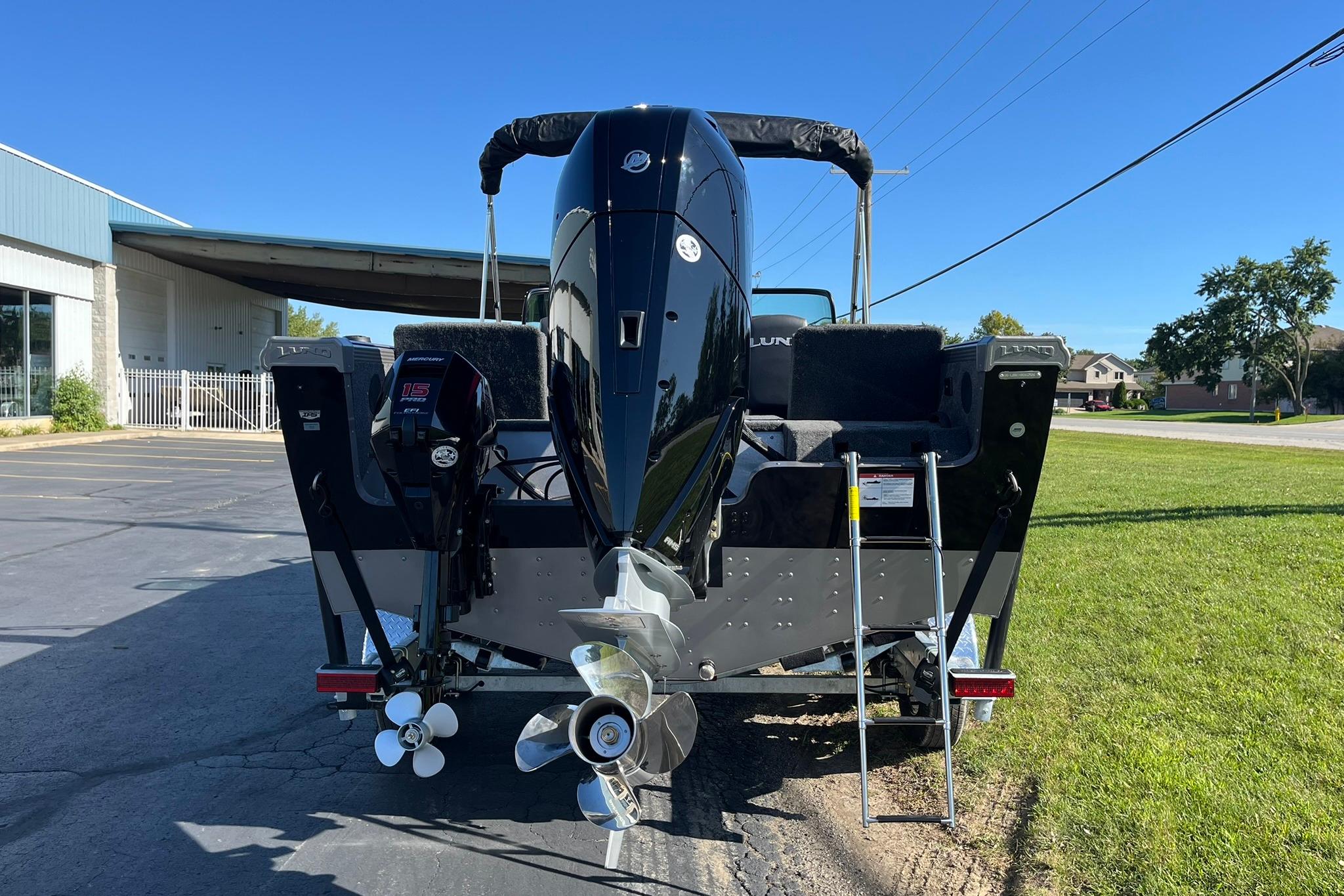 2026 Lund 2275 Baron boat rear view with dual outboard motors and ladder.