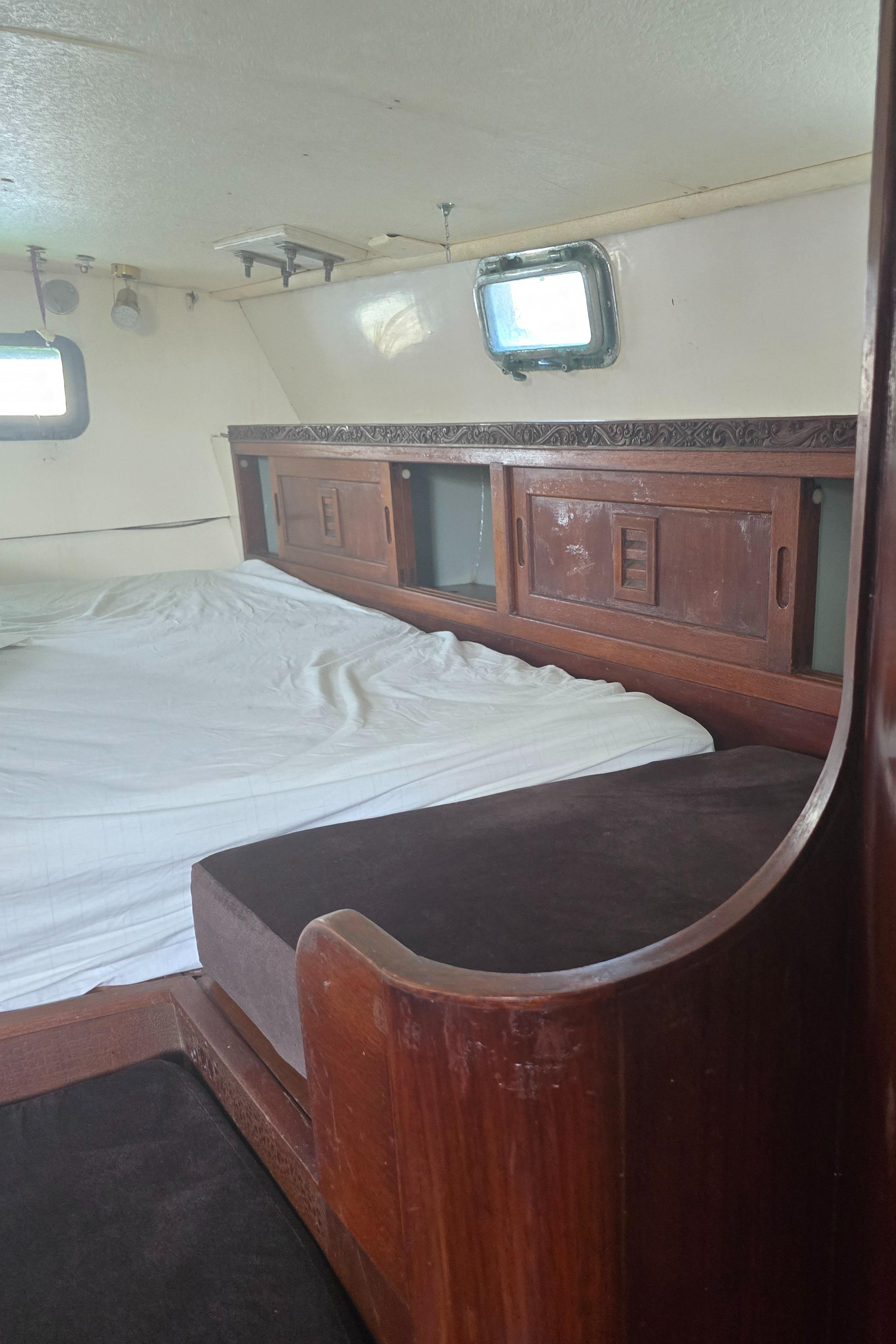 1978 Herreshoff 50 yacht interior with wooden cabinetry and bed.