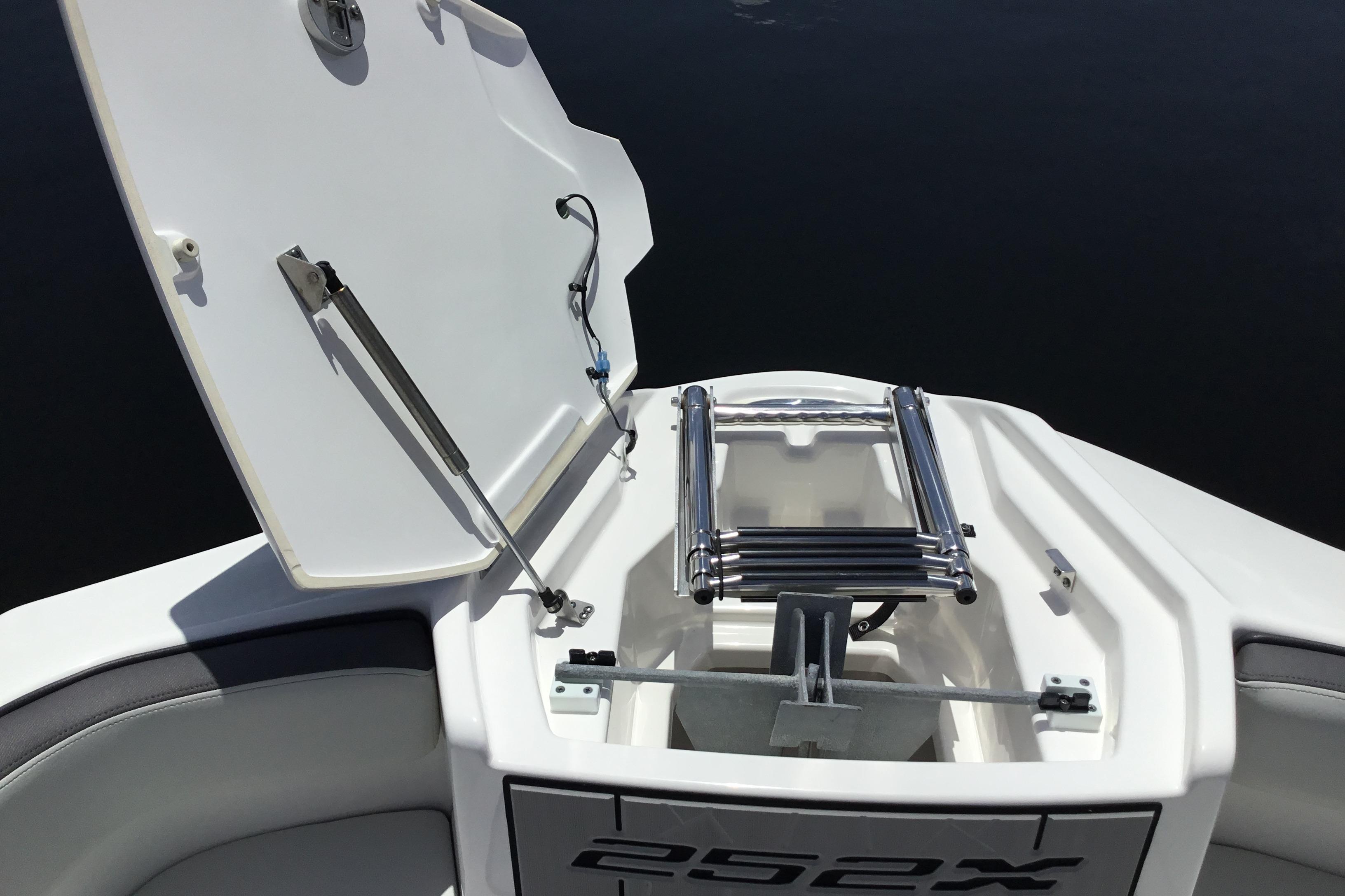 2023 Yamaha Boats 252XE bow storage with ladder and anchor compartment open.