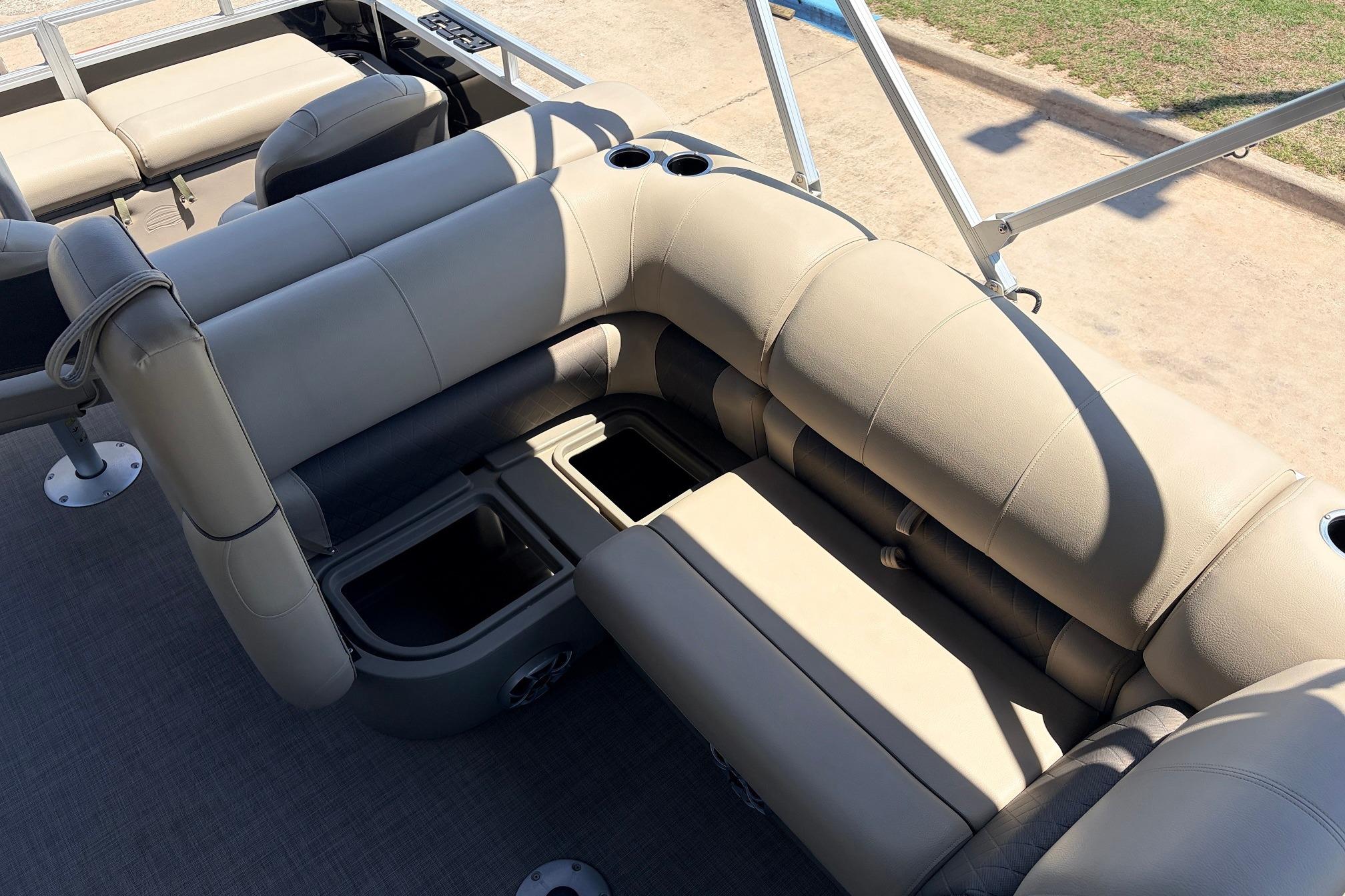 2024 Sun Tracker SportFish 22 XP3 pontoon boat interior with beige seating and storage compartments.