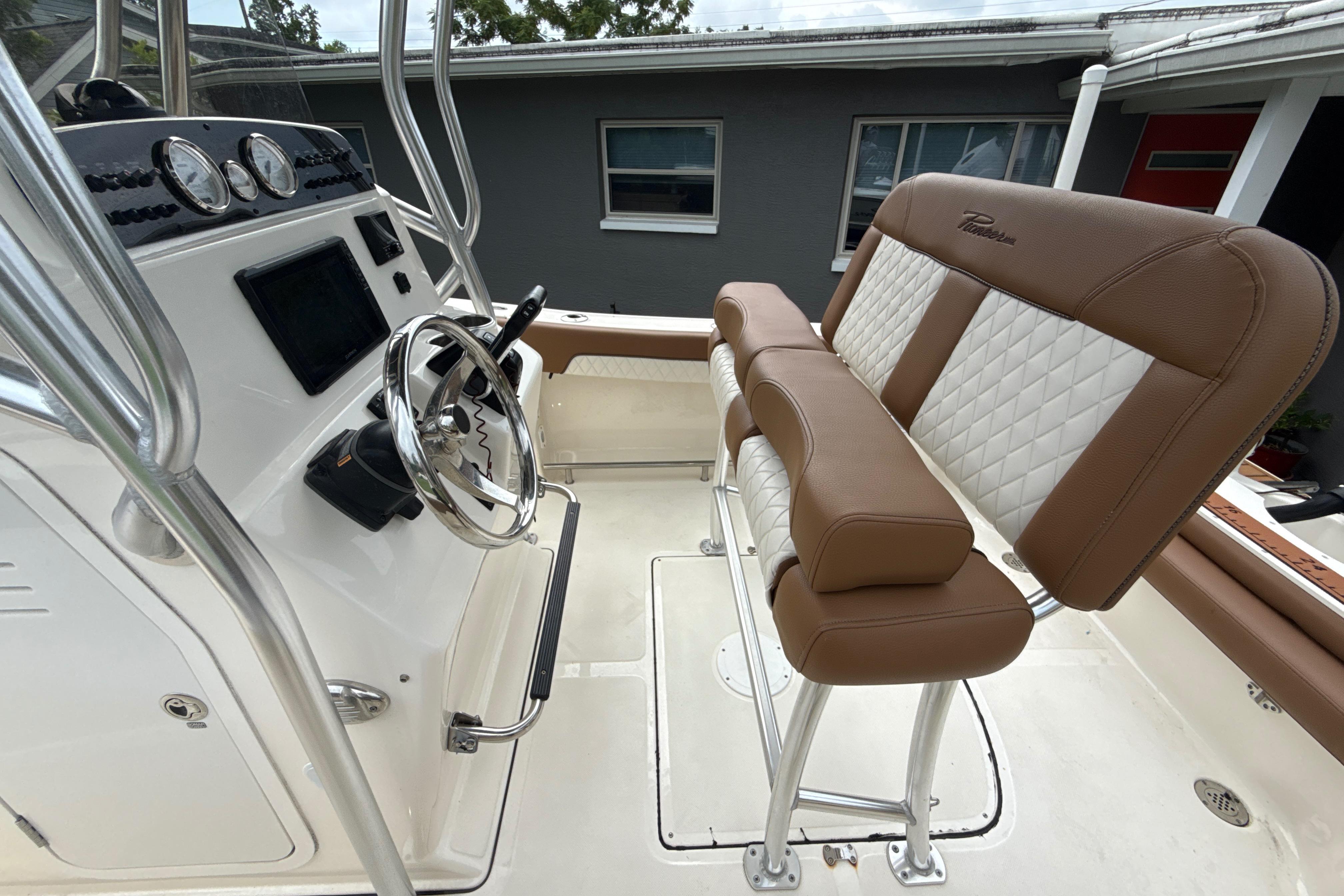 2023 Pioneer 202 Islander boat interior with steering wheel and cushioned seating.