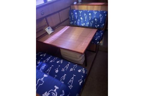 Vintage 1964 Striker model 120 boat interior with nautical-themed seating and wooden table.