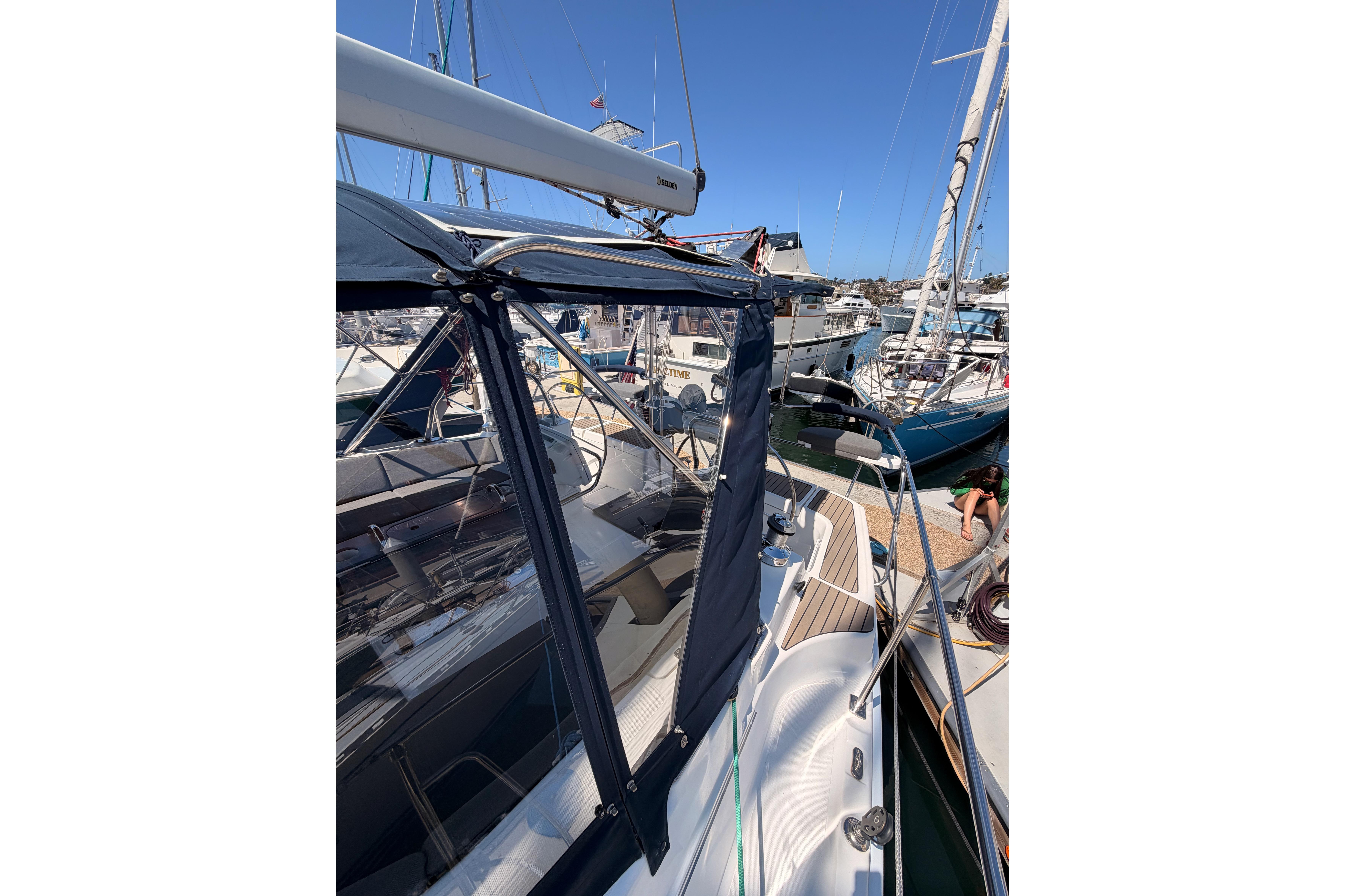 2008 Hunter 45 Deck Salon sailboat docked at marina, featuring sleek design and blue canopy.