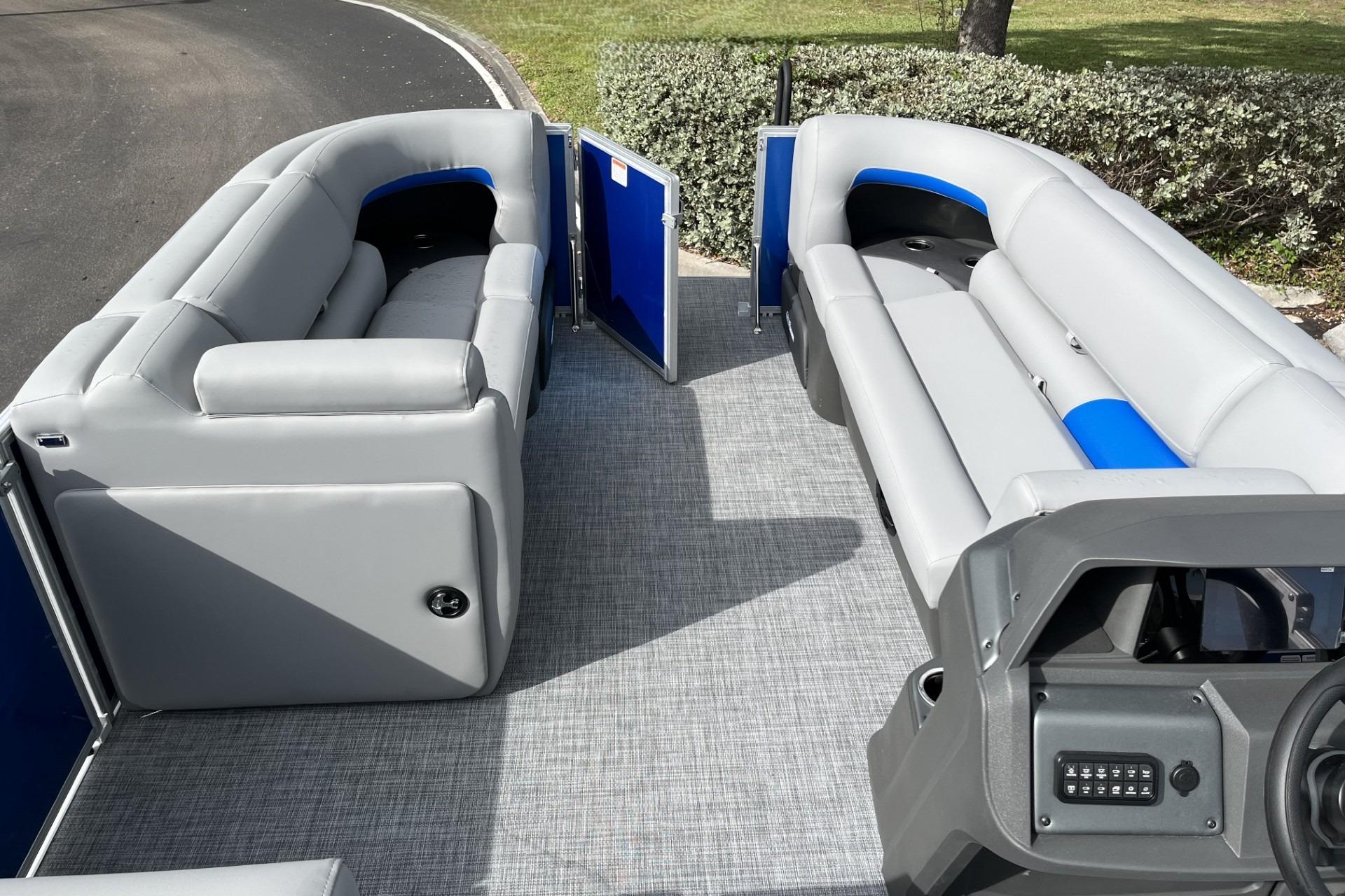 2026 Sun Tracker Party Barge 20 DLX interior with gray seating and modern dashboard.