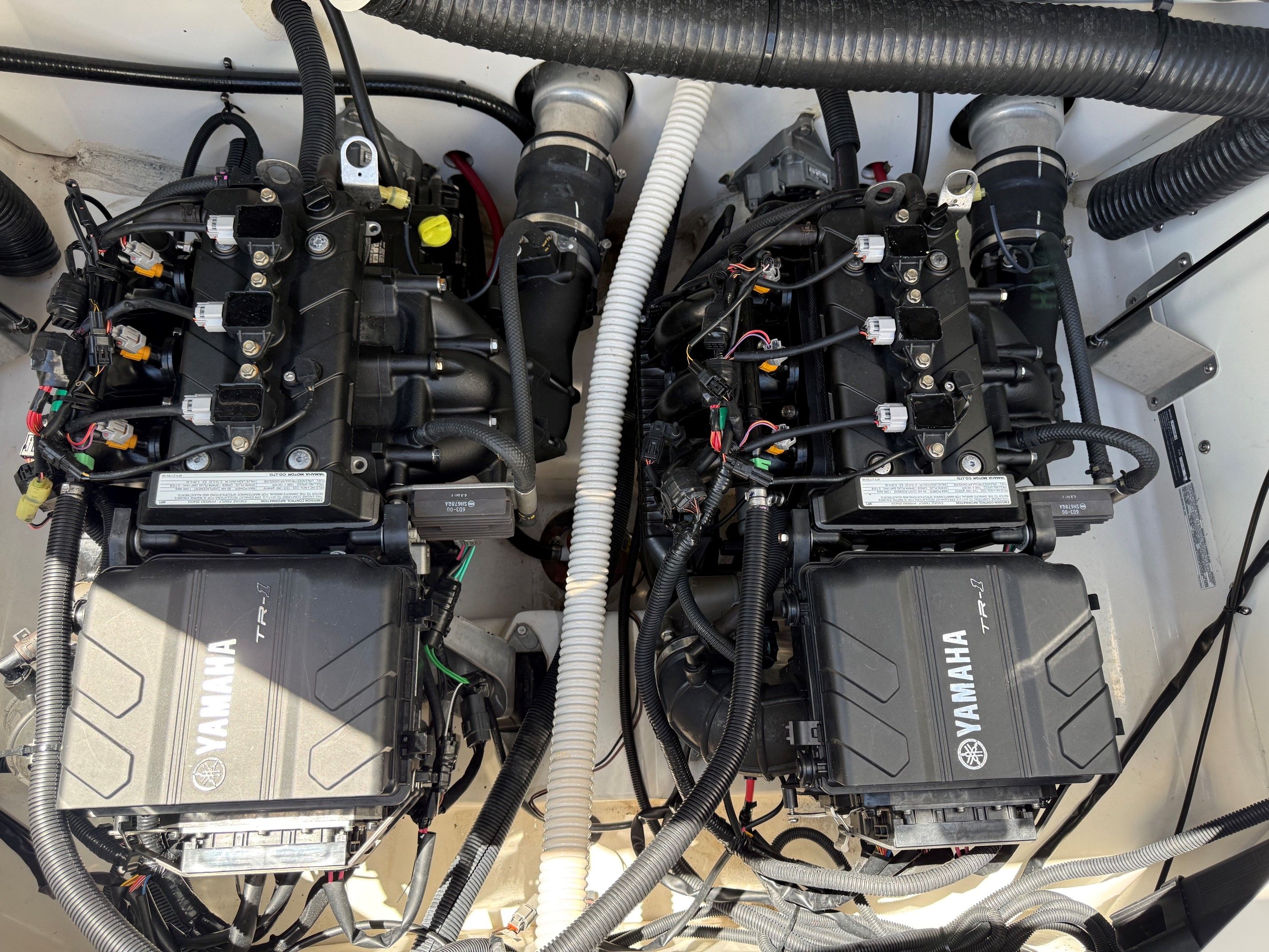 Two Yamaha engines inside a boat, surrounded by hoses and cables.