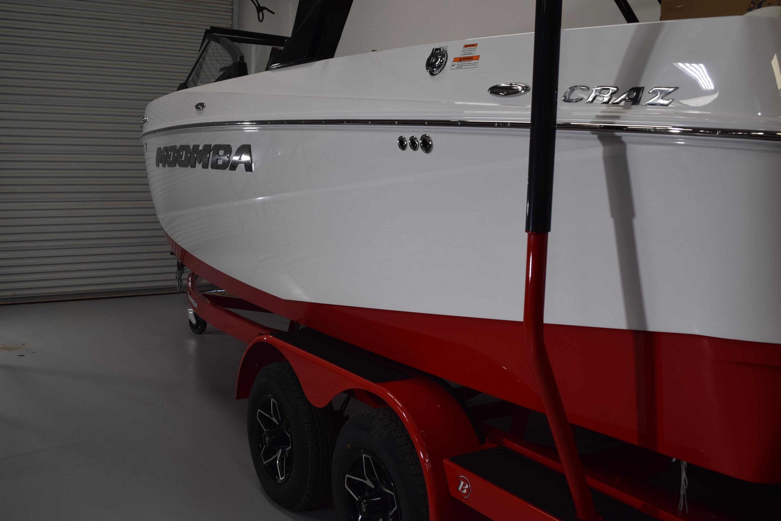 2026 Moomba Craz boat with red trailer in a garage setting.