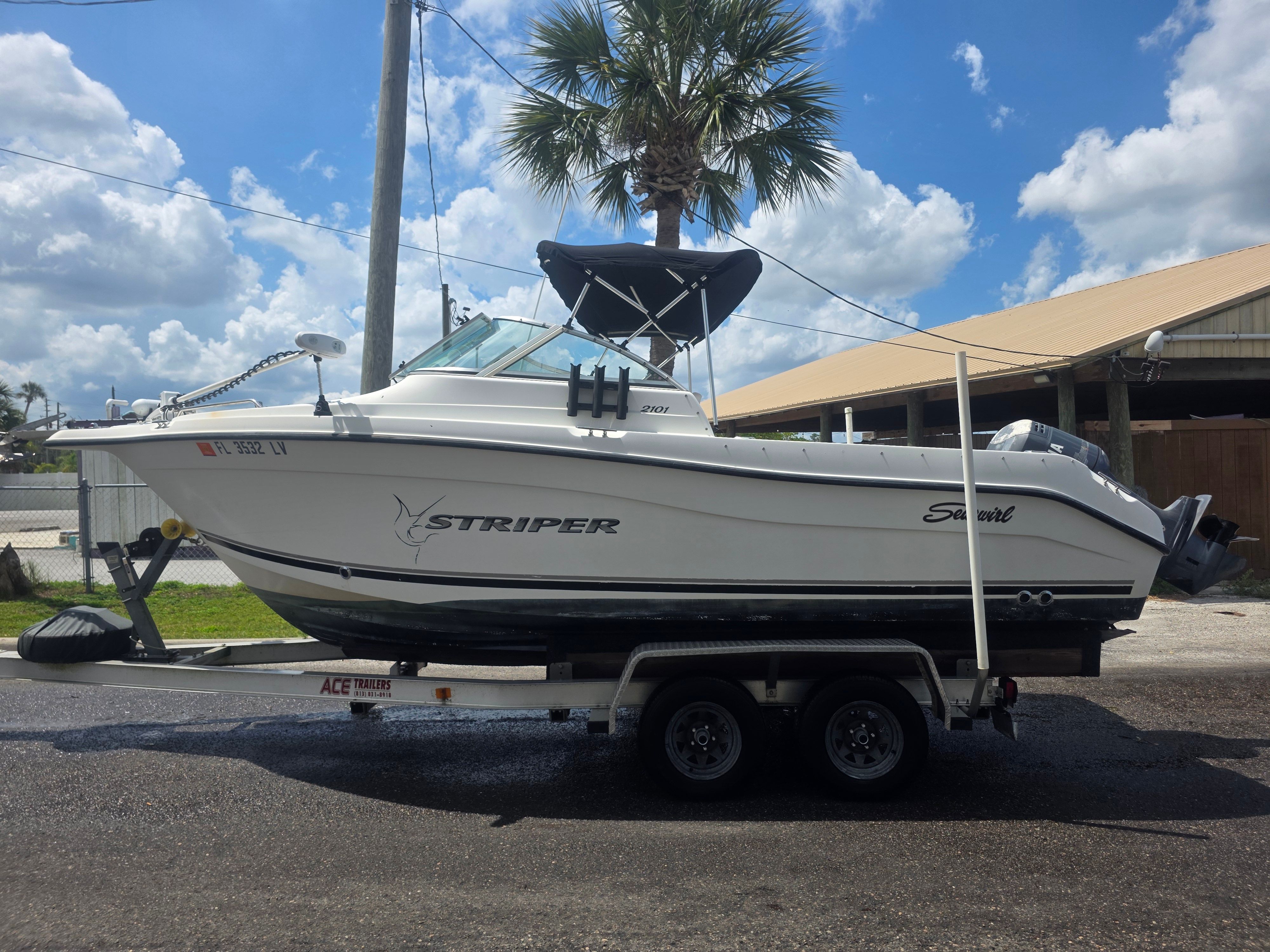 A 2002 Seaswirl Striper 2101 DC on a trailer, featuring a black bimini top.