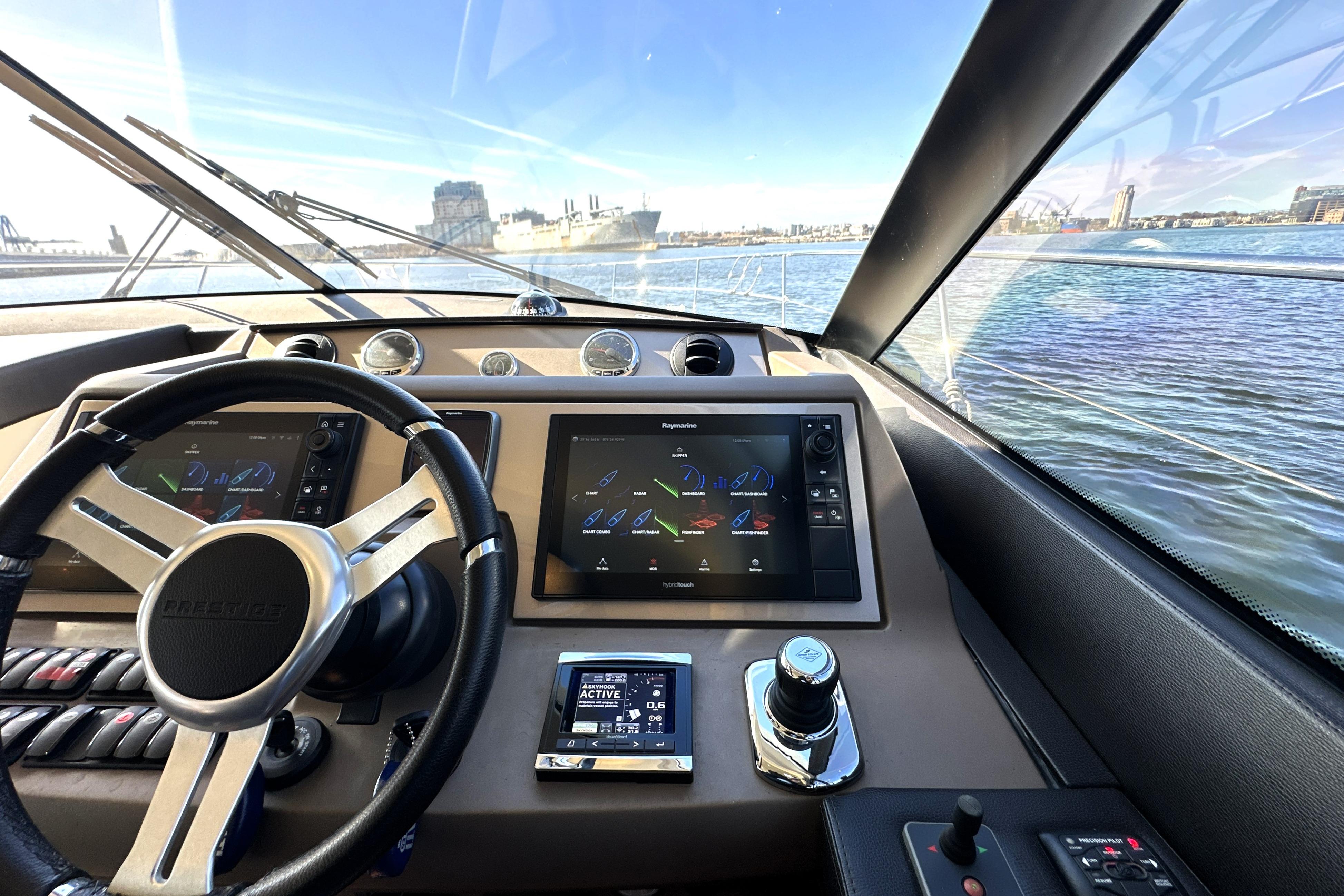 Interior view of a 2016 Prestige 550 yacht cockpit with navigation screens.