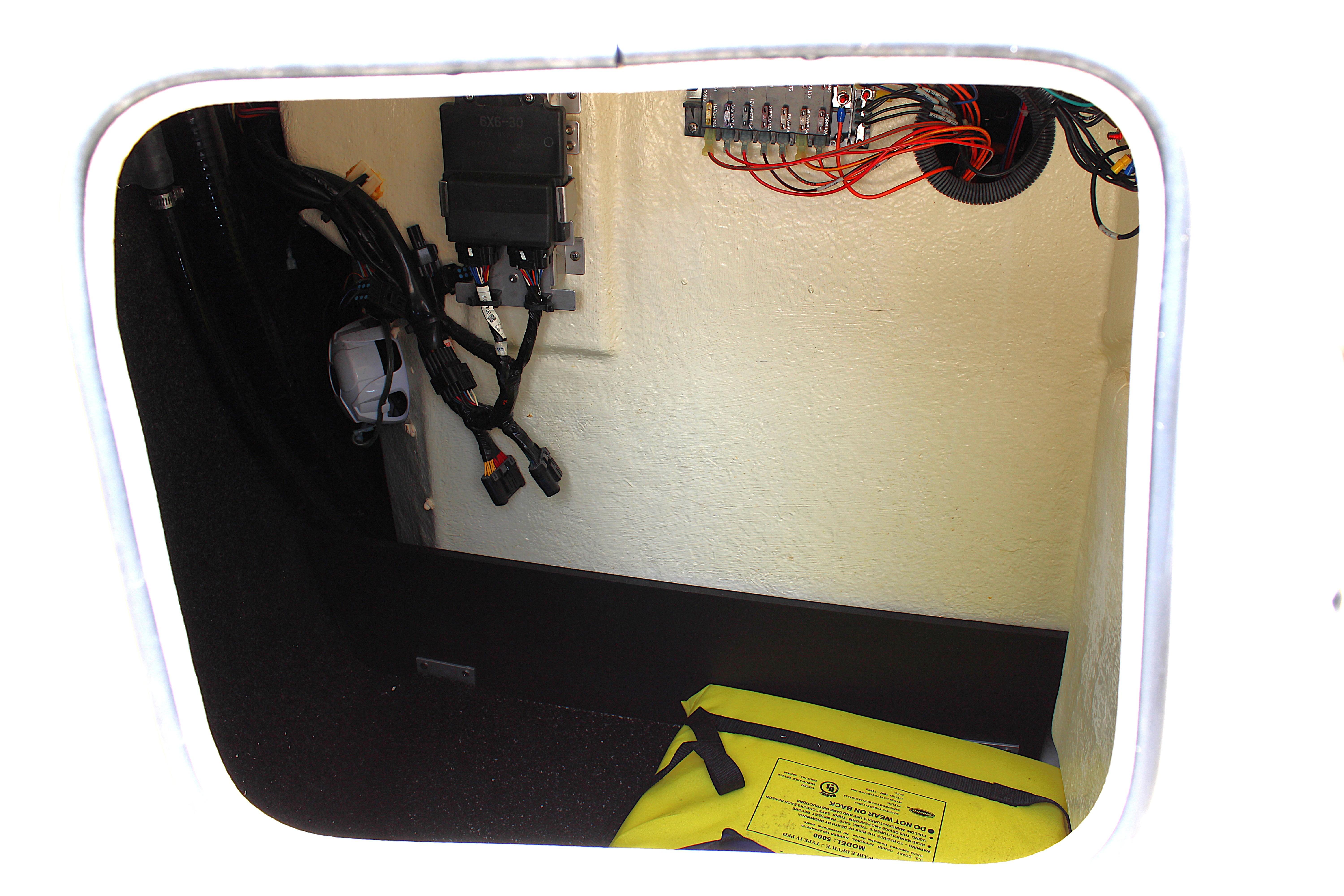 2021 Regal 26 OBX boat storage compartment with wiring and safety equipment.