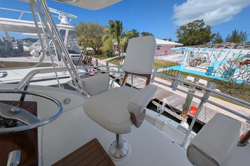 Captain's chair on 2005 Egg Harbor 43 SportYacht, docked with clear skies and palm trees.