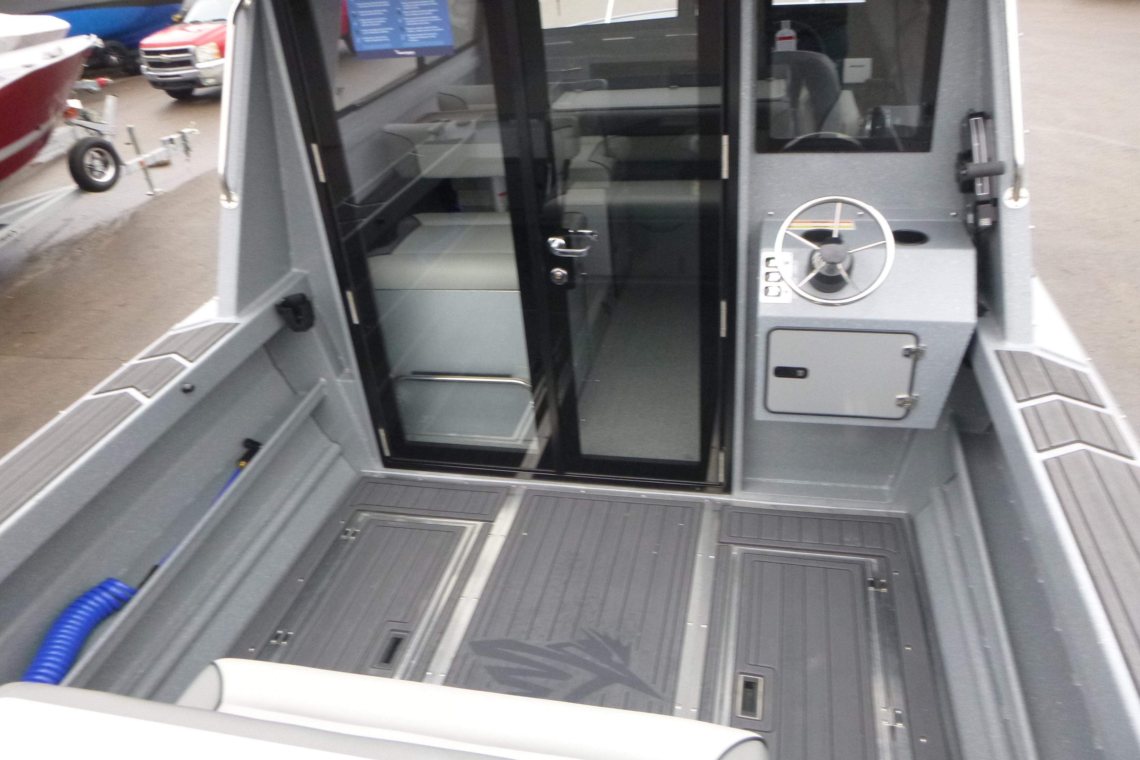 2026 KingFisher 25 XAC boat interior with steering wheel and seating area.