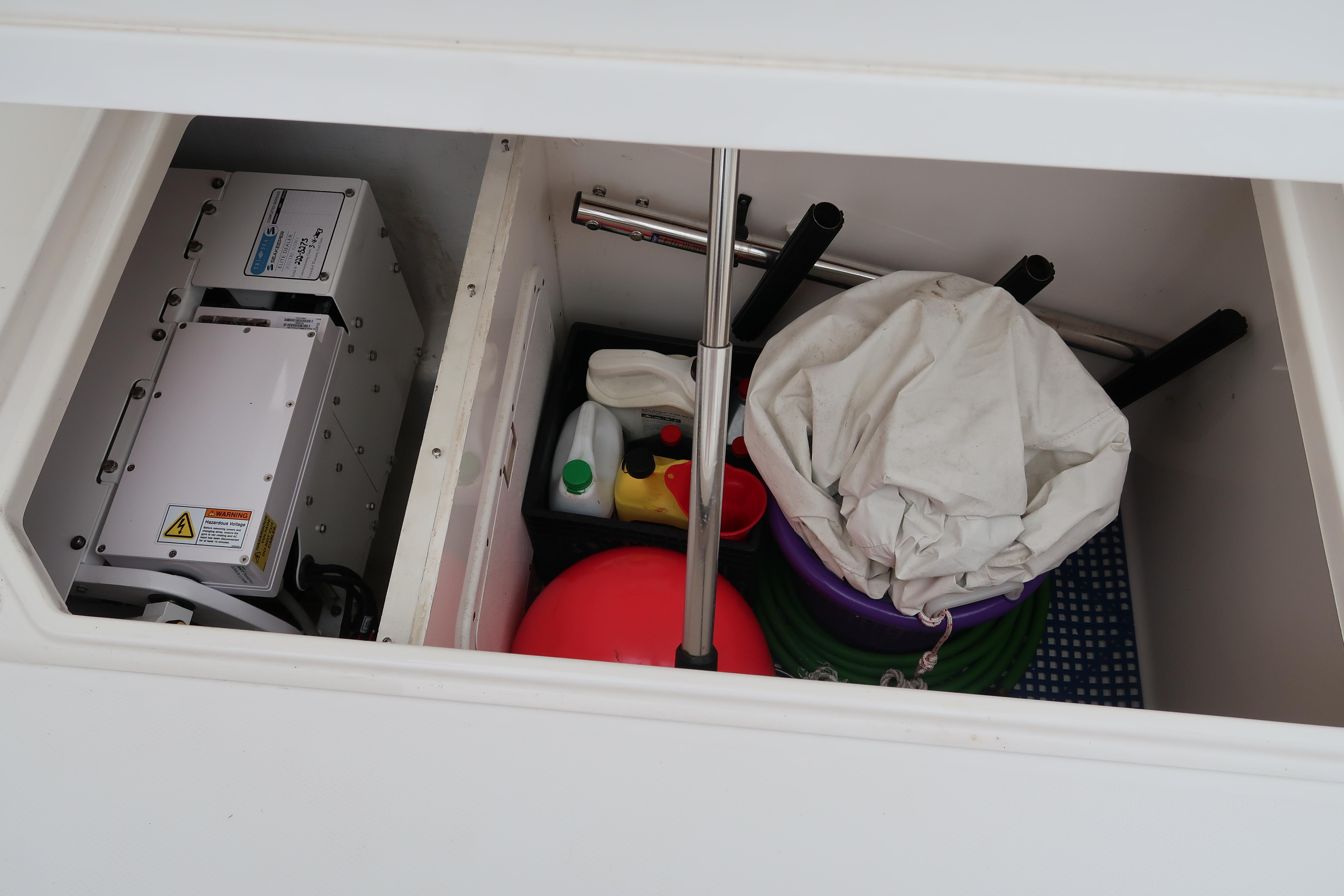 Storage compartment of a 2016 Invincible 42 Open Fisherman boat with cleaning supplies.