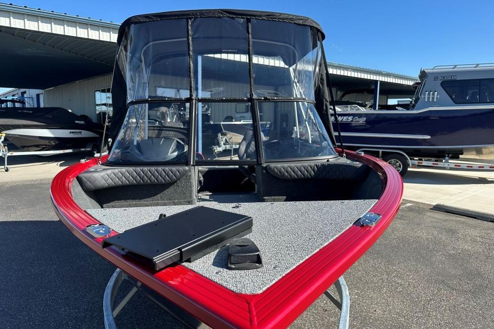 2026 Starweld 17 SXT boat with red trim and windshield, parked outdoors.