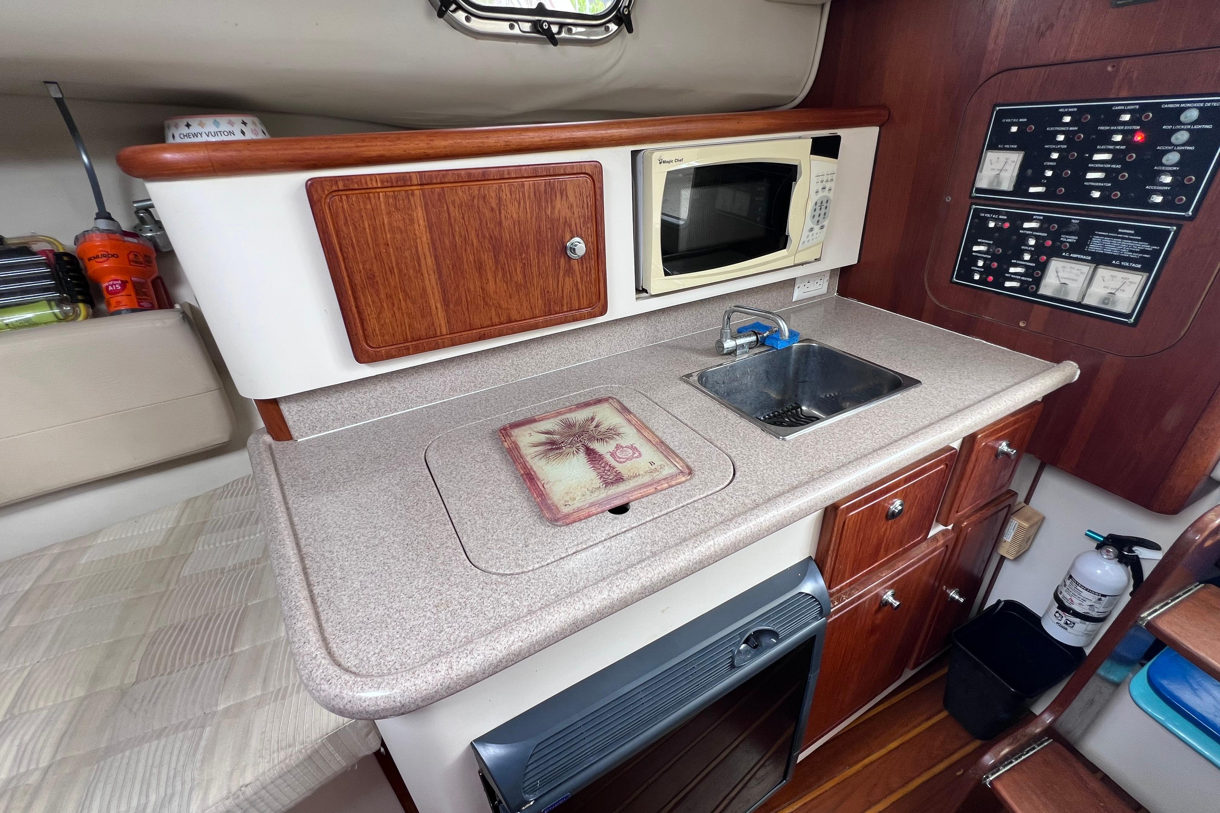2005 Pursuit 3070 Offshore boat kitchen with microwave, sink, and control panel.