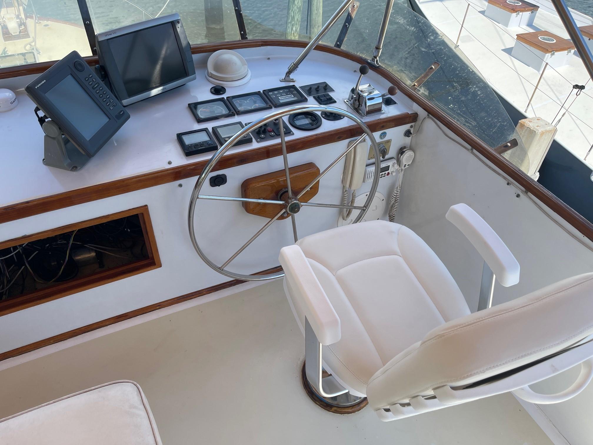 1979 Jarvis Newman Trawler helm with steering wheel, navigation equipment, and captain's chair.
