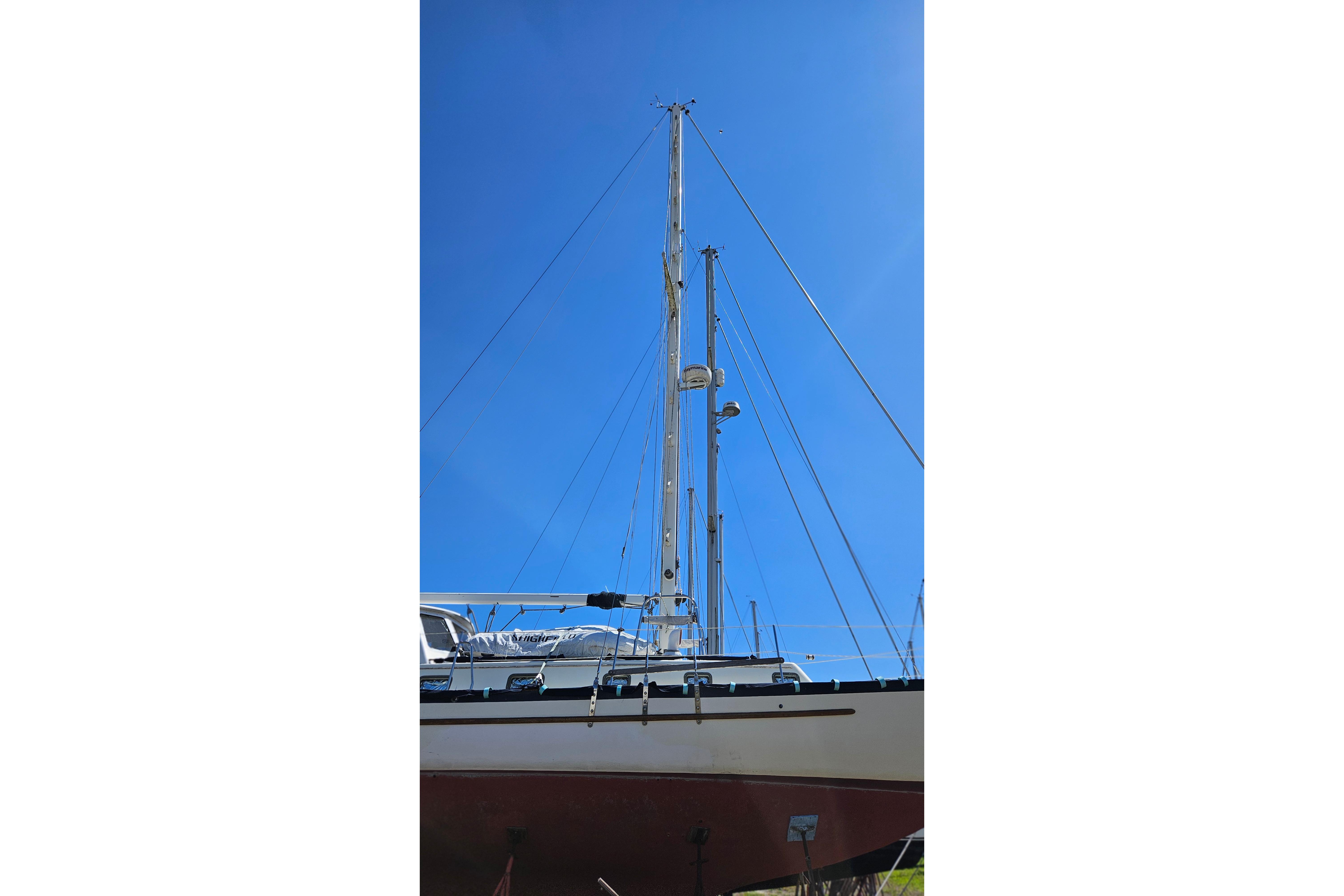 1989 Pacific Seacraft 37 sailboat mast against clear blue sky.