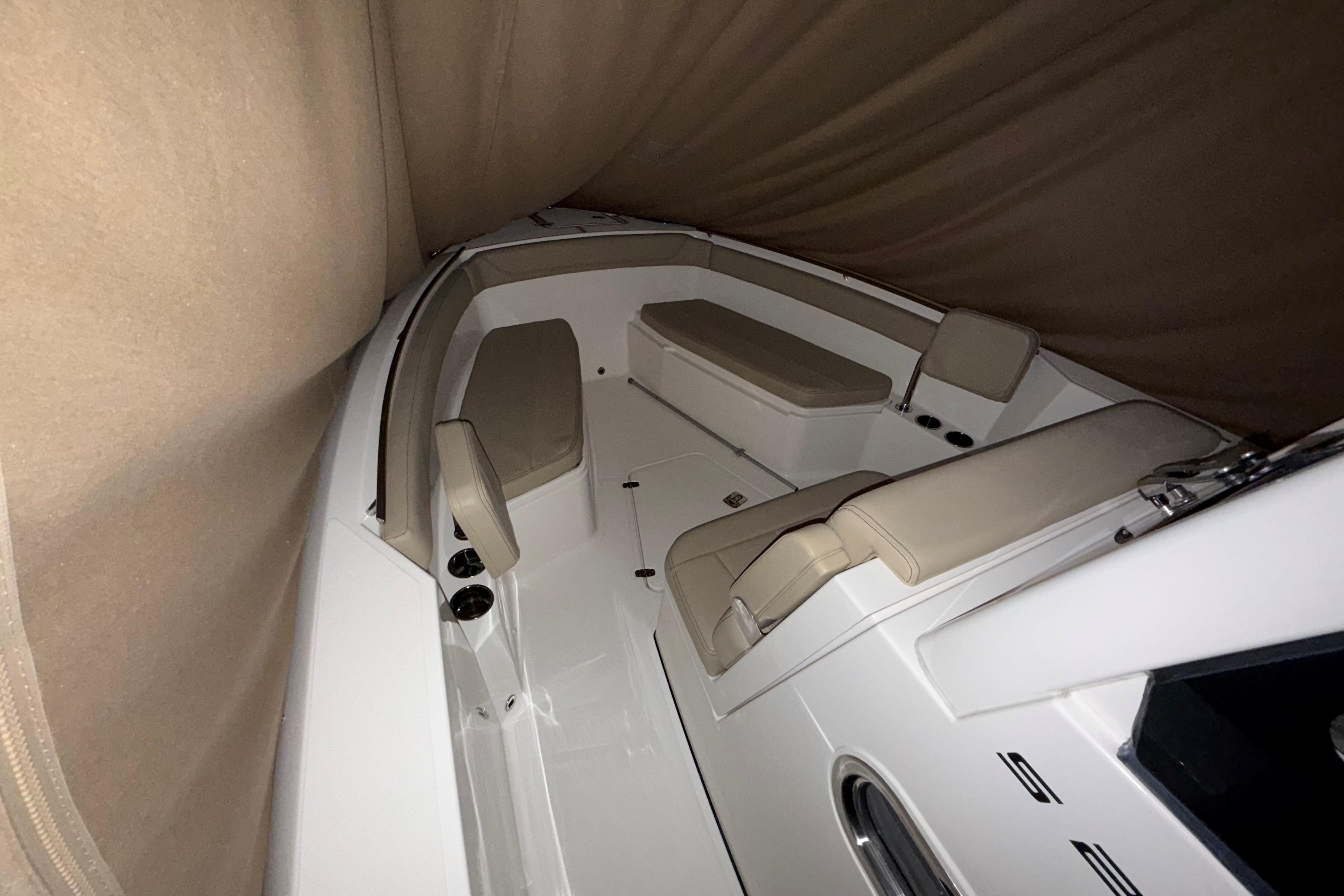 2021 Pursuit S 268 Sport boat interior with beige seating and covered deck.