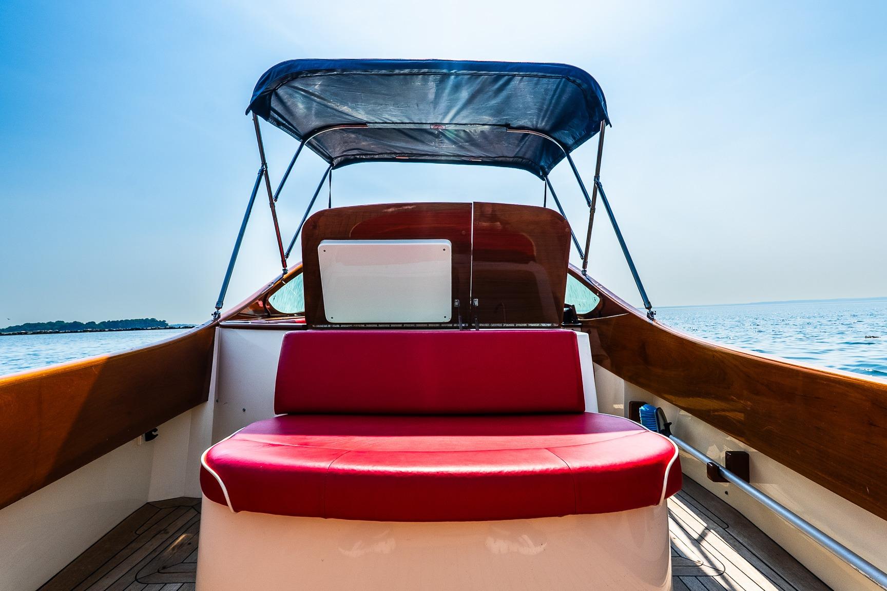 2005 Hinckley Talaria 29R boat interior with red seating and canopy on a sunny day.