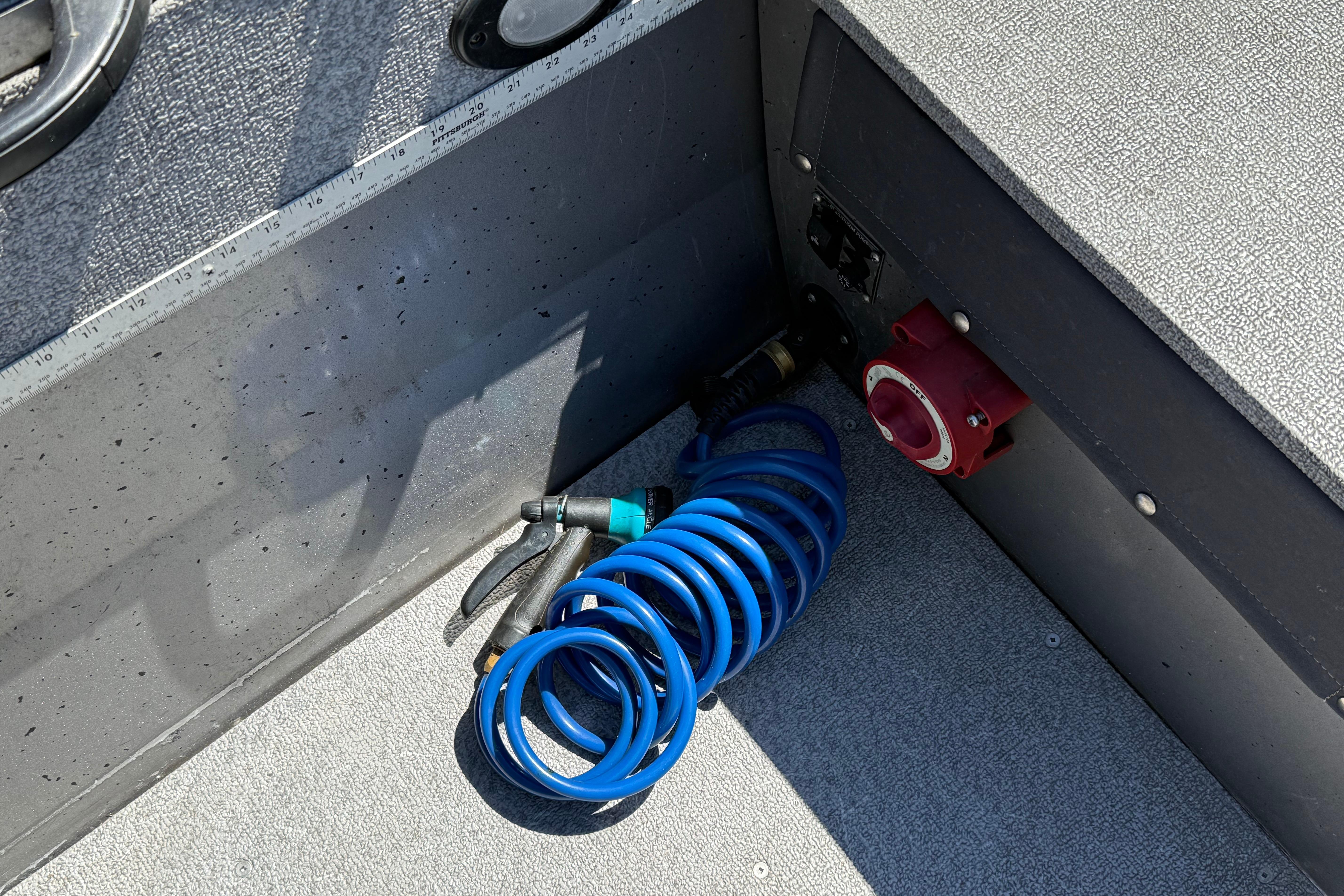Coiled blue hose on 2016 Crestliner 1700 Vision boat floor, near red valve.