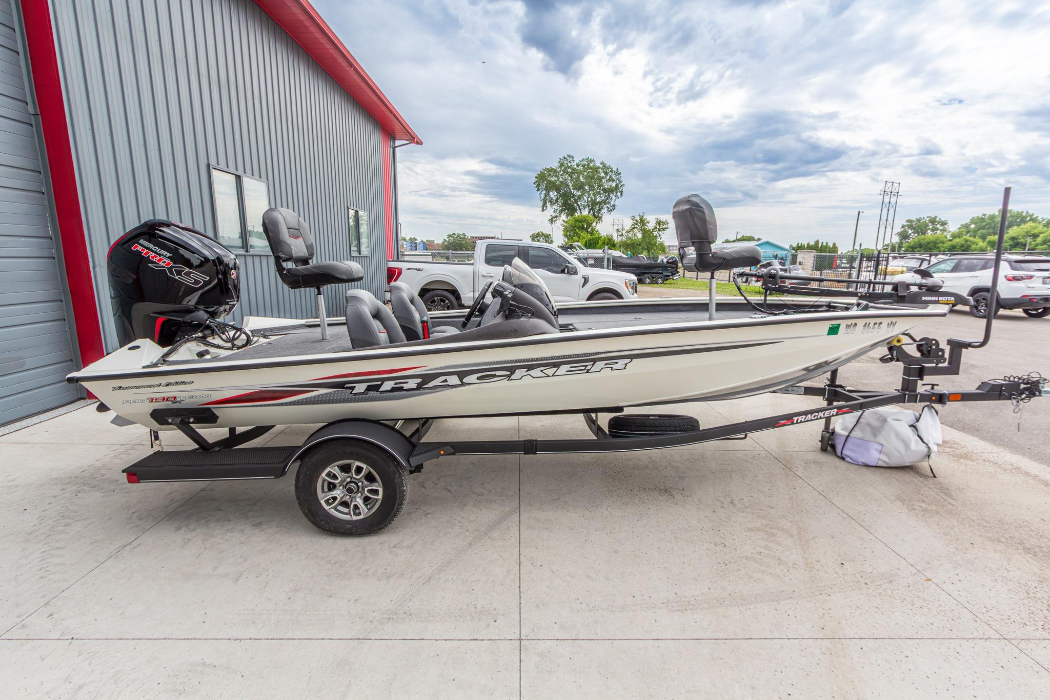 2023 Tracker Pro Team 190 TX boat on trailer, parked outside a building.