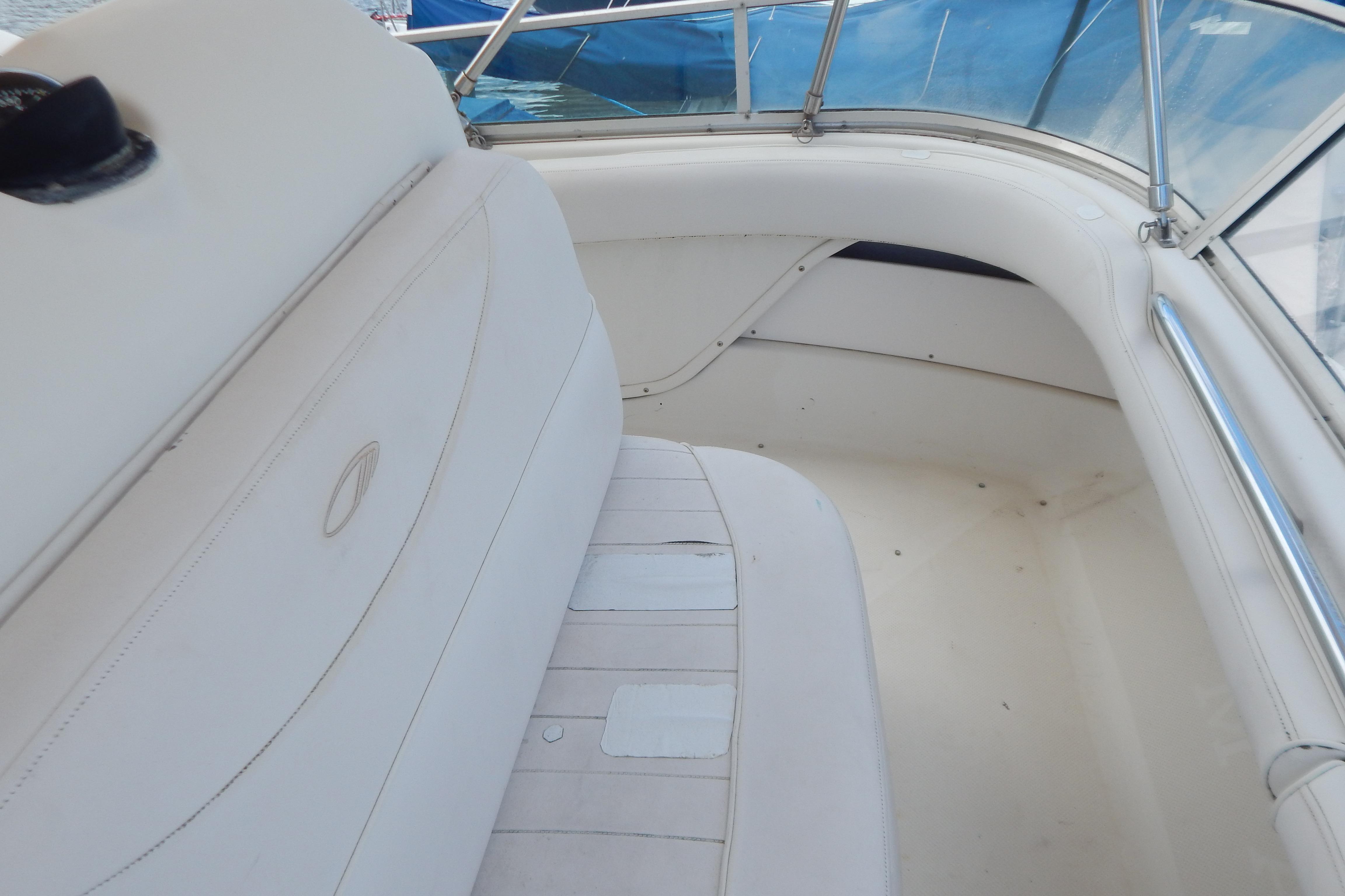 Interior of a 1998 Magnum 4100 SCR boat, featuring white seating and blue-tinted windows.