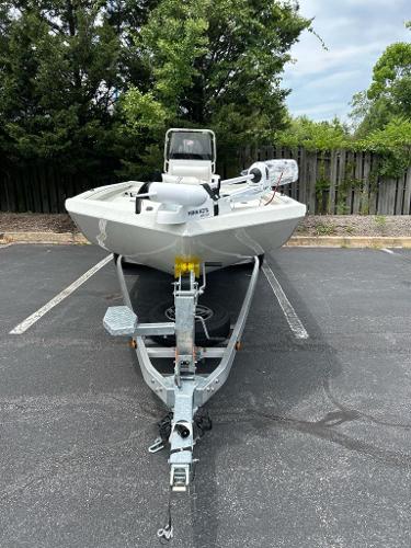 2024 Ranger RB210 boat on trailer in parking lot, surrounded by trees.