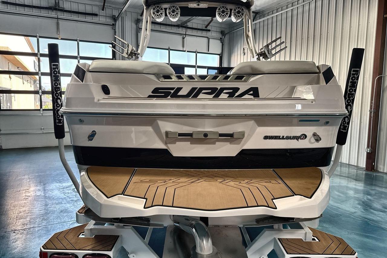 2020 Supra SE boat in a garage, showcasing sleek design and Swell Surf technology.