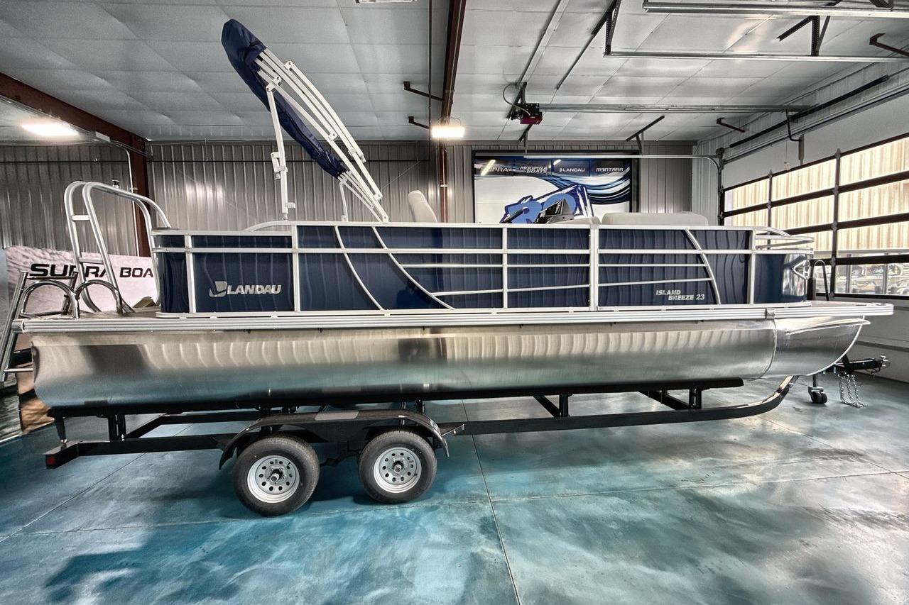 2026 Landau Island Breeze 23F pontoon boat in a showroom on a trailer.