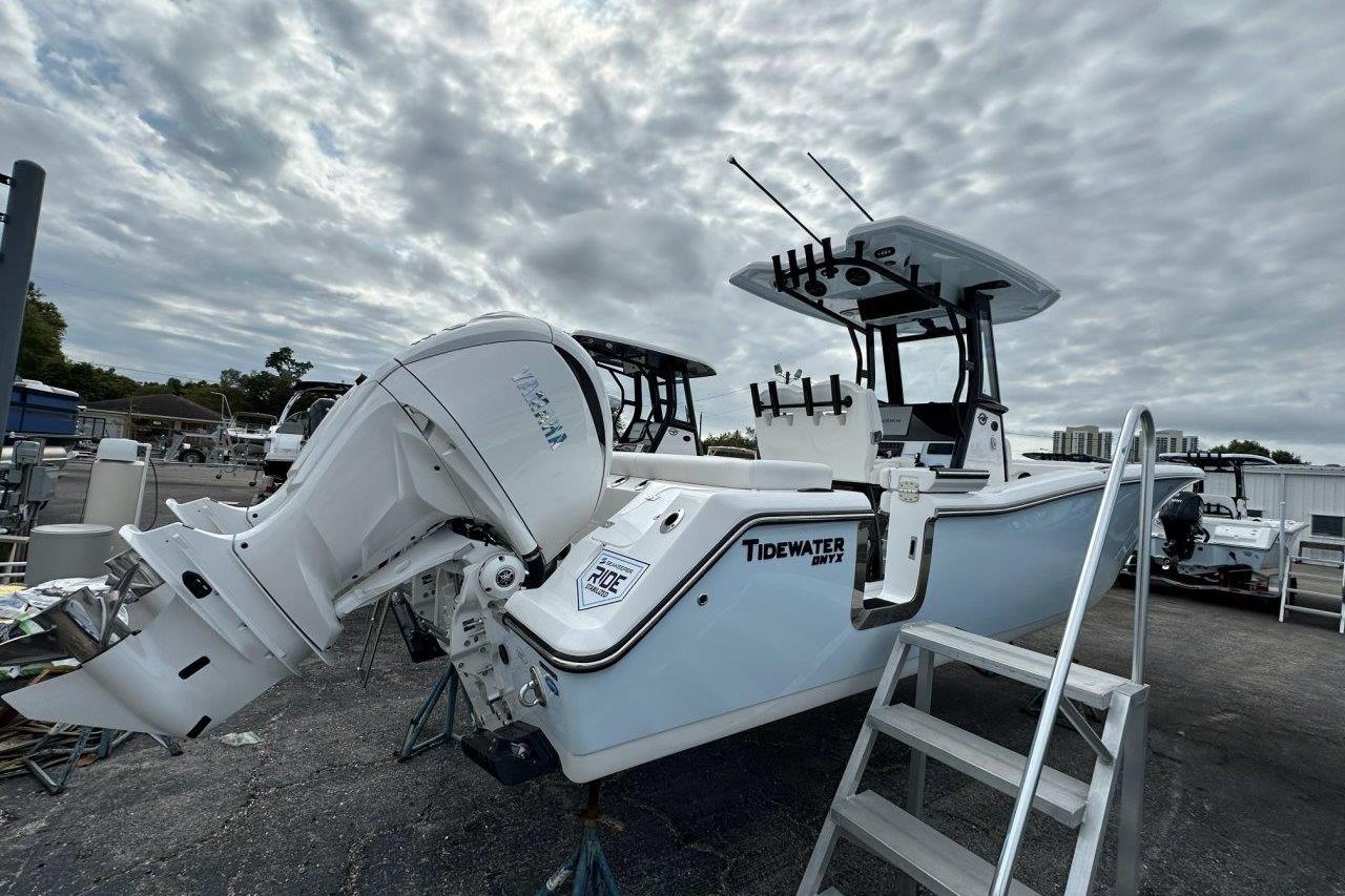 2026 Tidewater 272 LXF boat with powerful outboard motor, docked under cloudy skies.