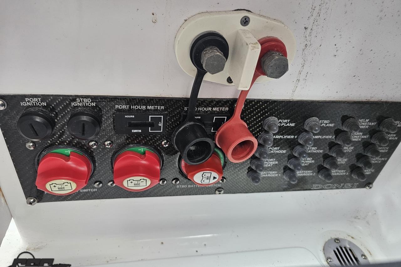 Control panel of a 2008 Donzi 38 ZR boat with ignition switches and hour meter.