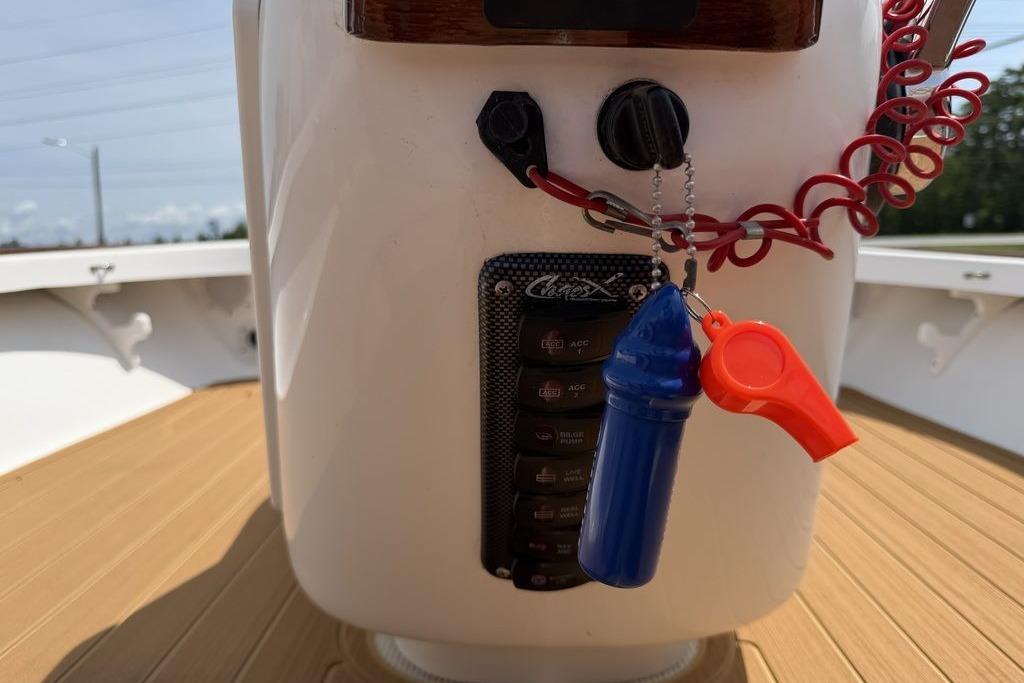 Control panel of a 2012 Chaos 16 Bonefish boat with safety whistle and lanyard.
