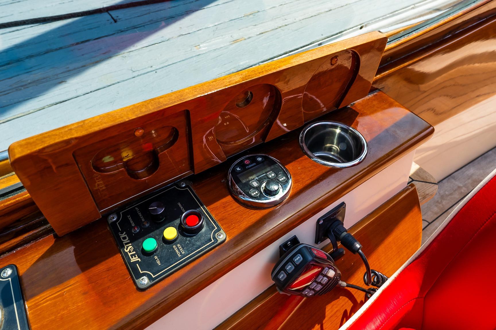 Control panel of a 2005 Hinckley Talaria 29R boat with joystick and cup holder.