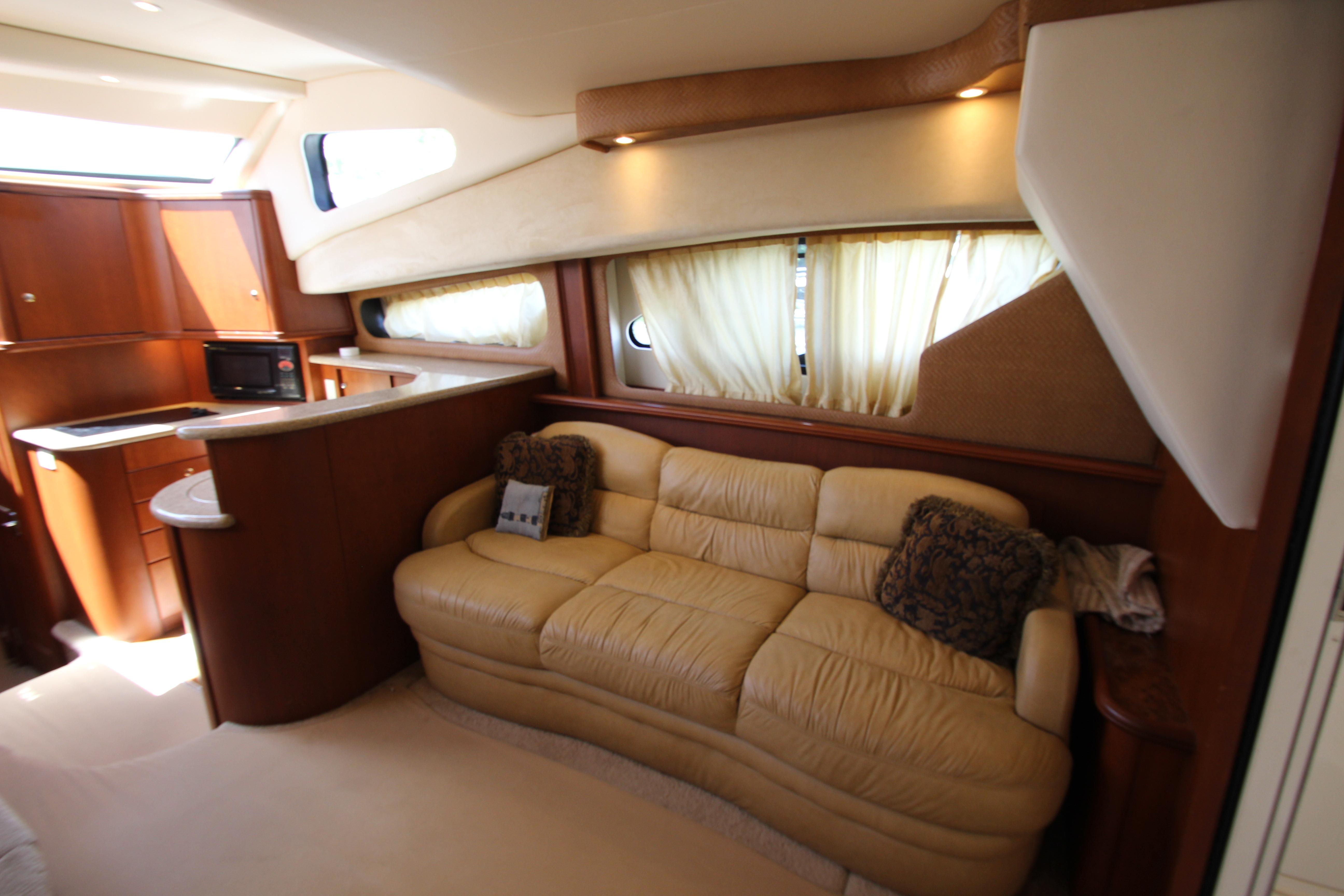 Interior of 2006 Silverton 38 Sport Bridge yacht with beige sofa and kitchenette.