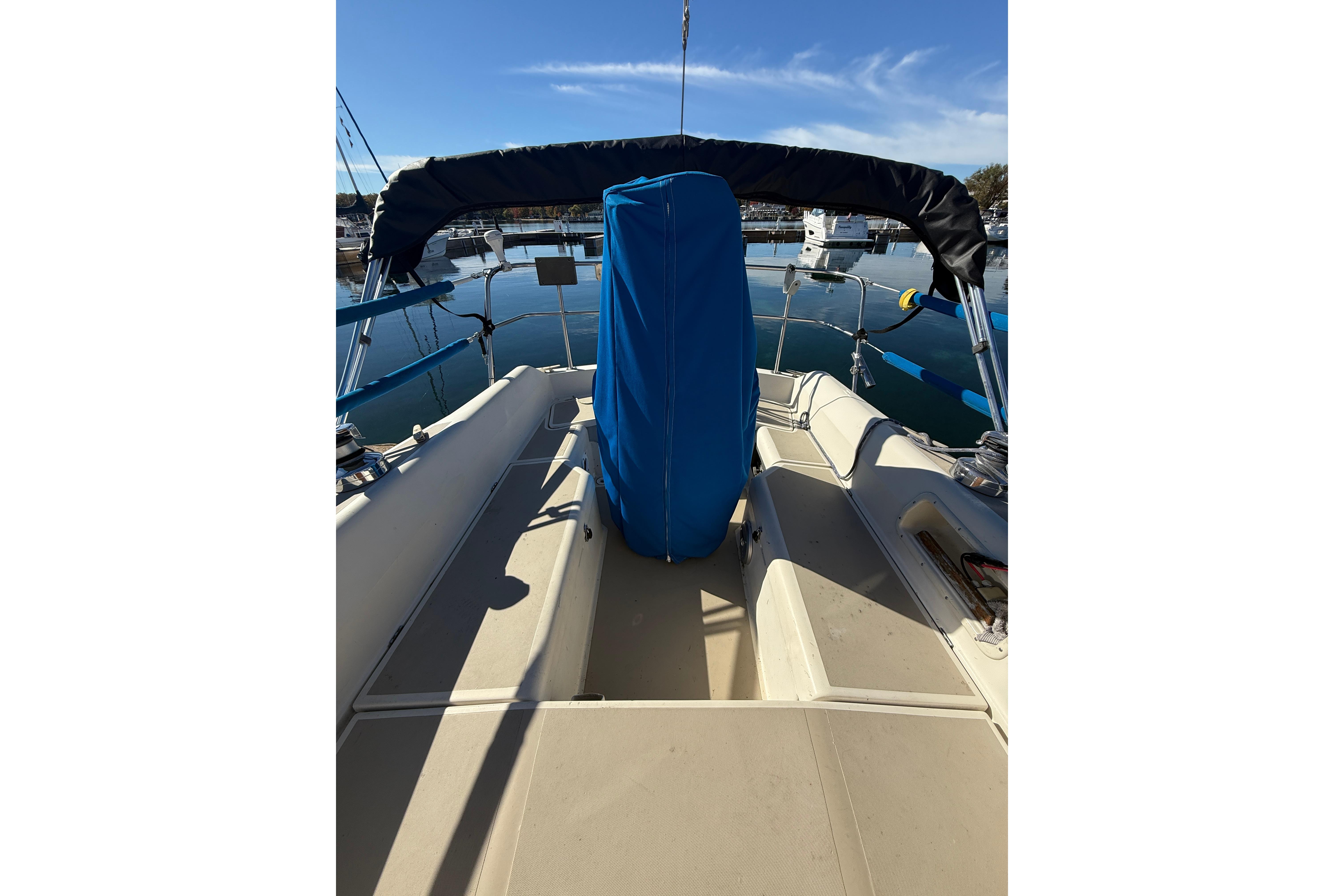 1983 O'Day 34 sailboat cockpit with blue cover, docked in marina.