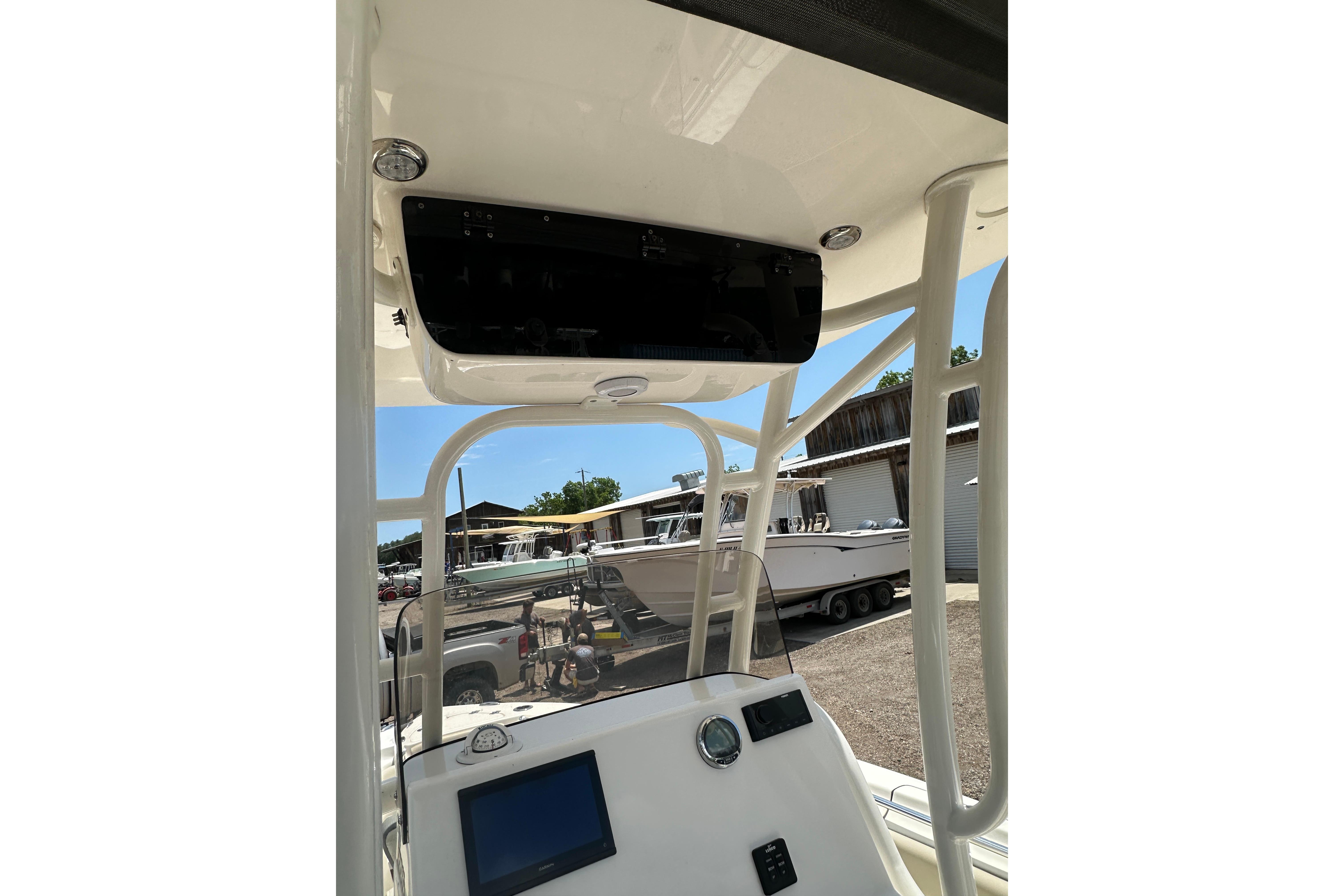 2025 Key West 219 FS boat console with electronics, docked in a marina under clear skies.