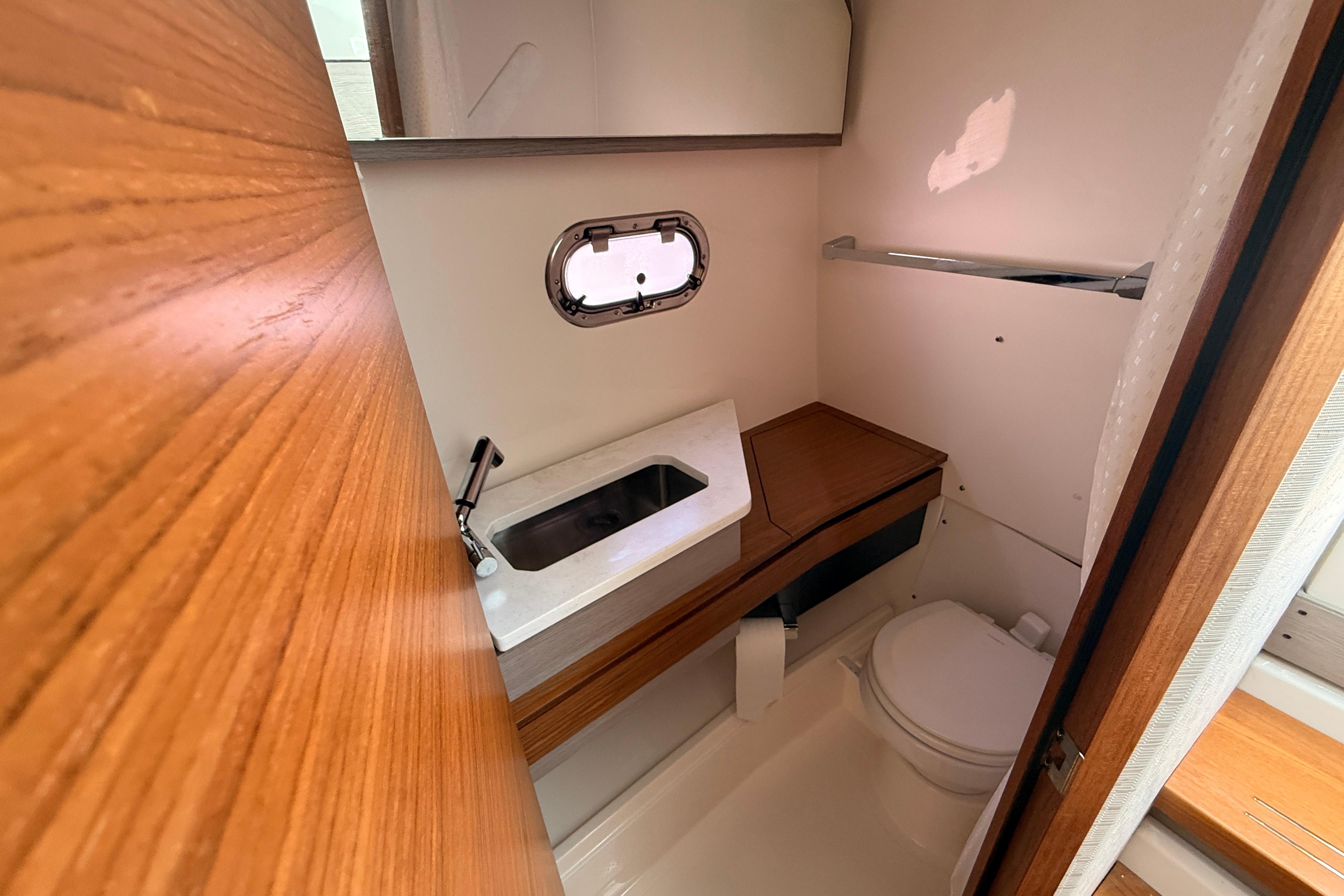 2024 Tiara Yachts 34 LS bathroom interior with sink, toilet, and wooden accents.
