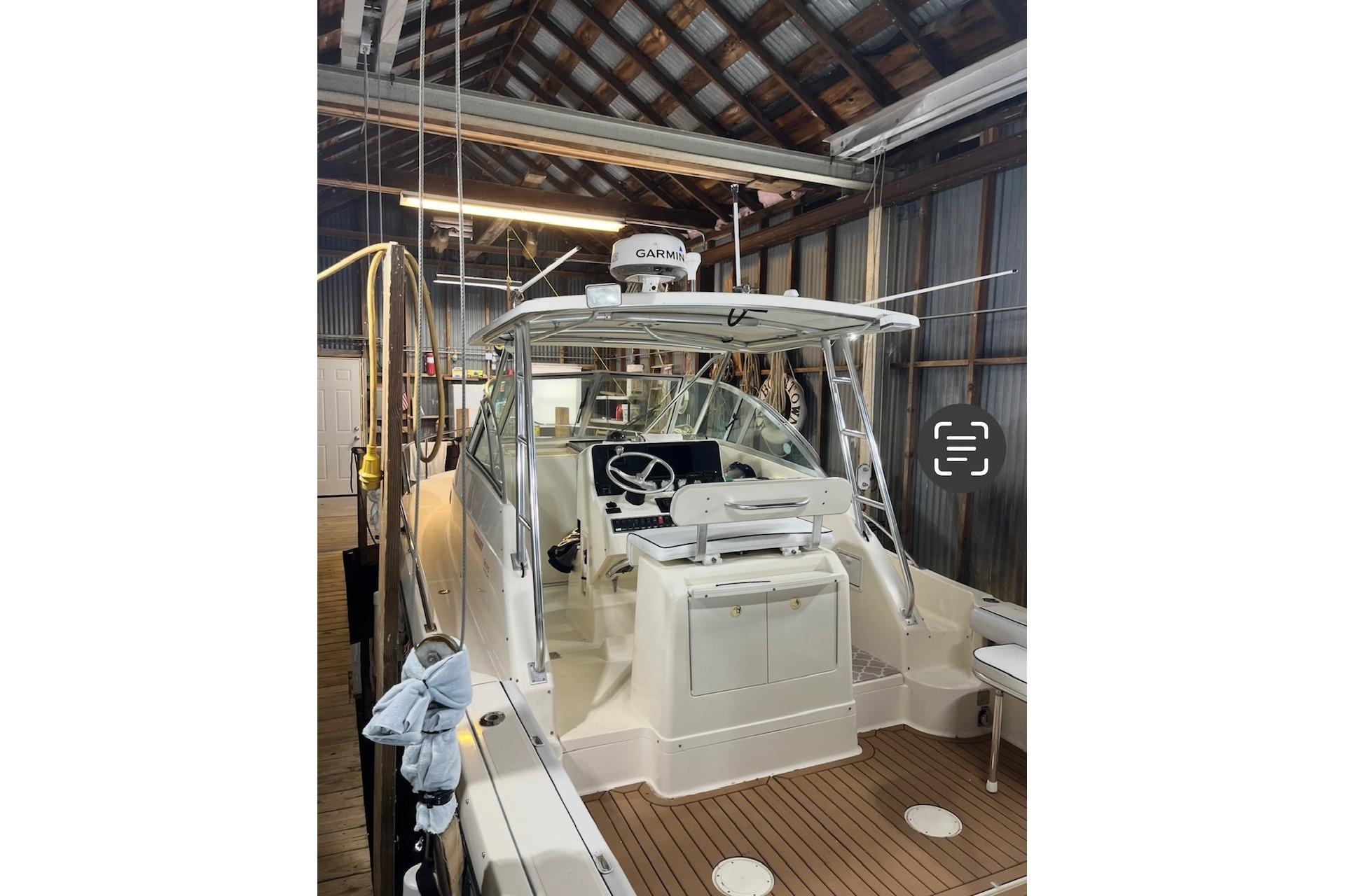 2000 Pursuit 3070 Offshore Center Console boat in a wooden boathouse.