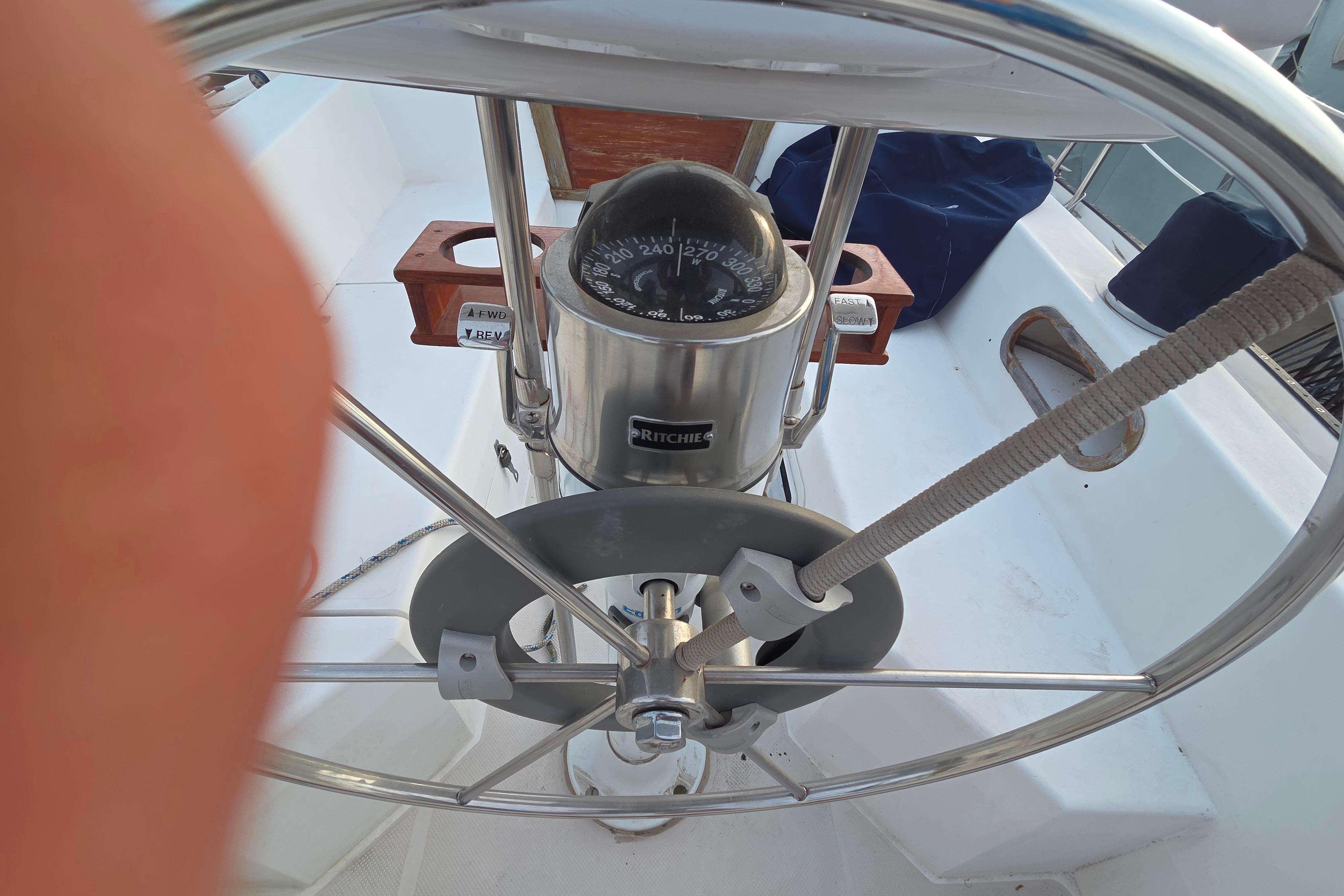 Steering wheel and compass of a 1986 Catalina 355 sailboat cockpit.