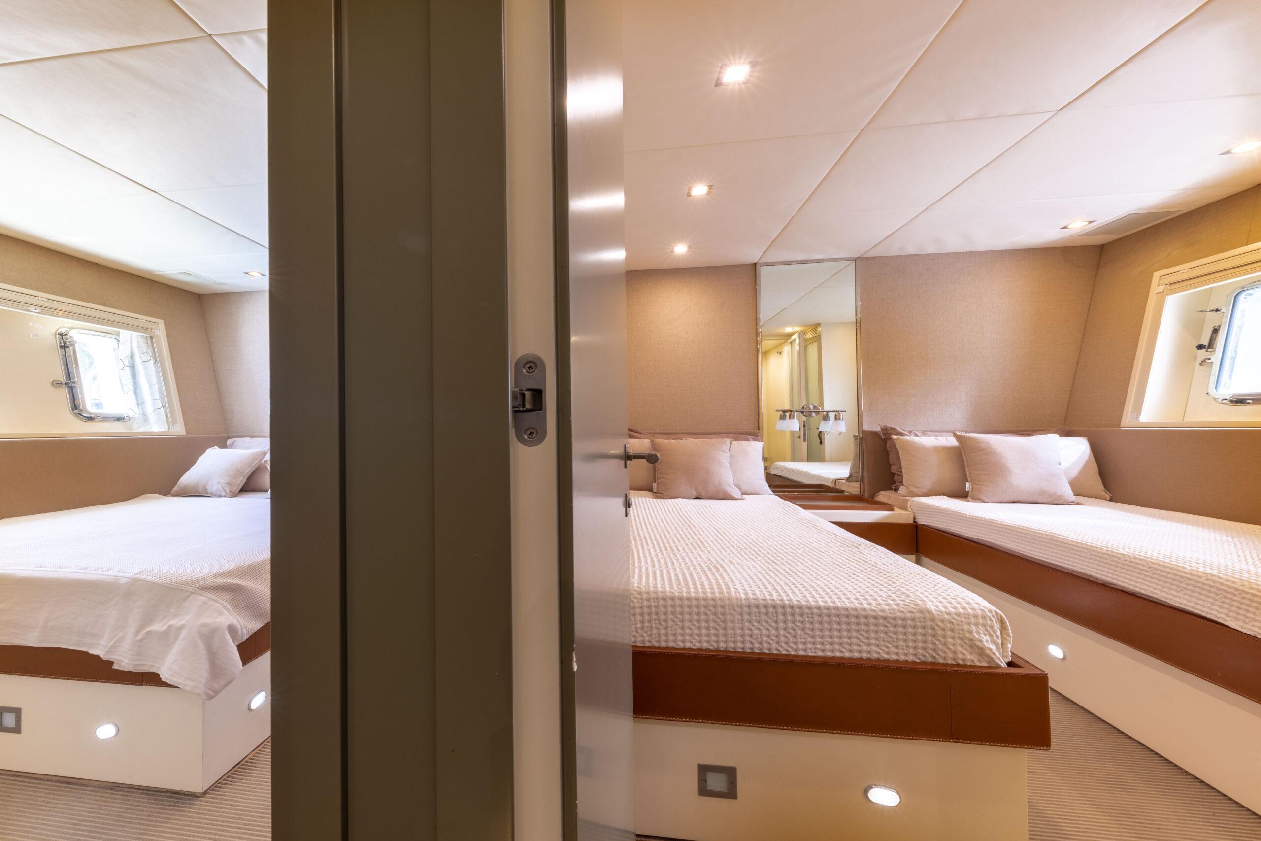 Luxurious 2006 Mangusta 80 yacht bedroom with twin beds and elegant decor.