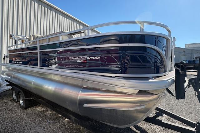 2025 Sun Tracker Fishin' Barge 22 XP3 pontoon boat on trailer, parked outdoors.