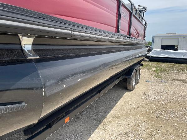 2023 Regency 250 DL3 pontoon boat on trailer, red and black exterior, parked outdoors.