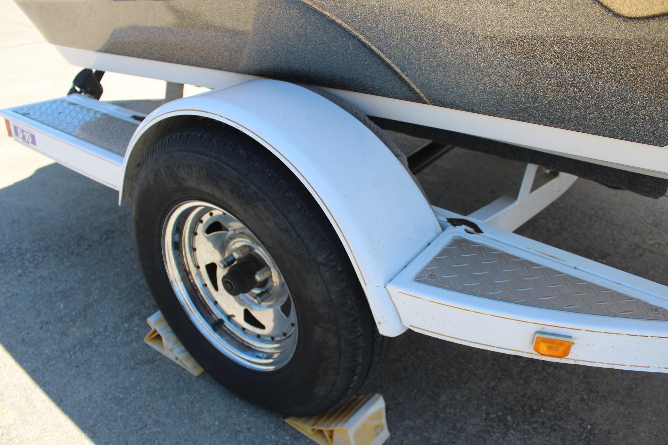 Trailer wheel of a 2003 Nitro NX 750 SC boat on a concrete surface.
