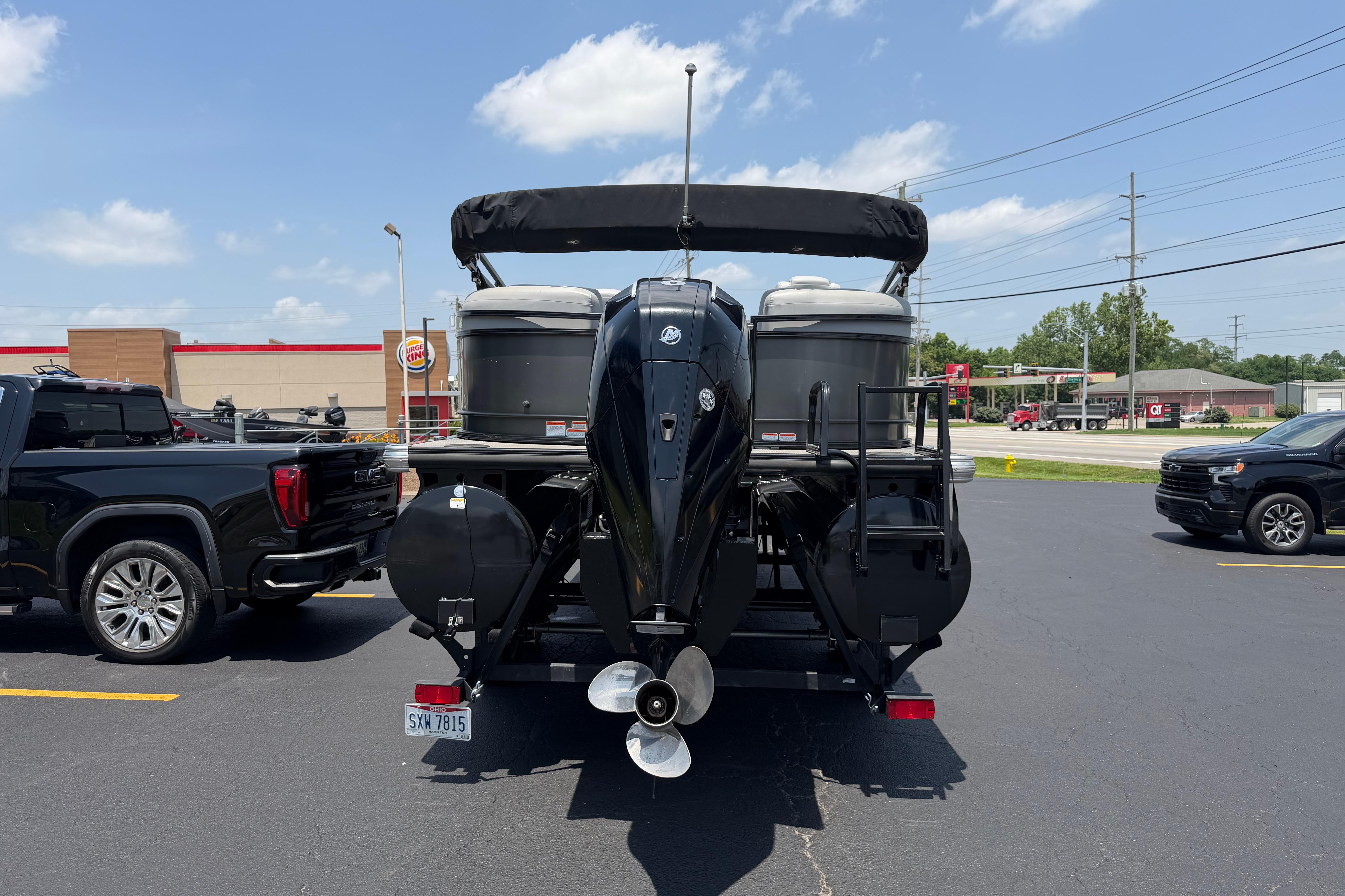 2019 Regency 230 DL3 pontoon boat on trailer in parking lot, sunny day.