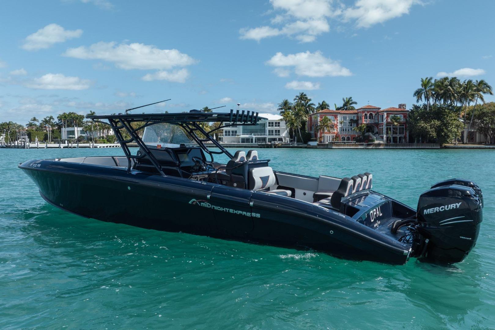 2014 Midnight Express 37 Open boat on turquoise water, with Mercury engines, near luxury waterfront homes.