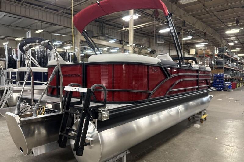 2026 Bennington 22 SSRSF pontoon boat in a factory setting, featuring a red exterior.
