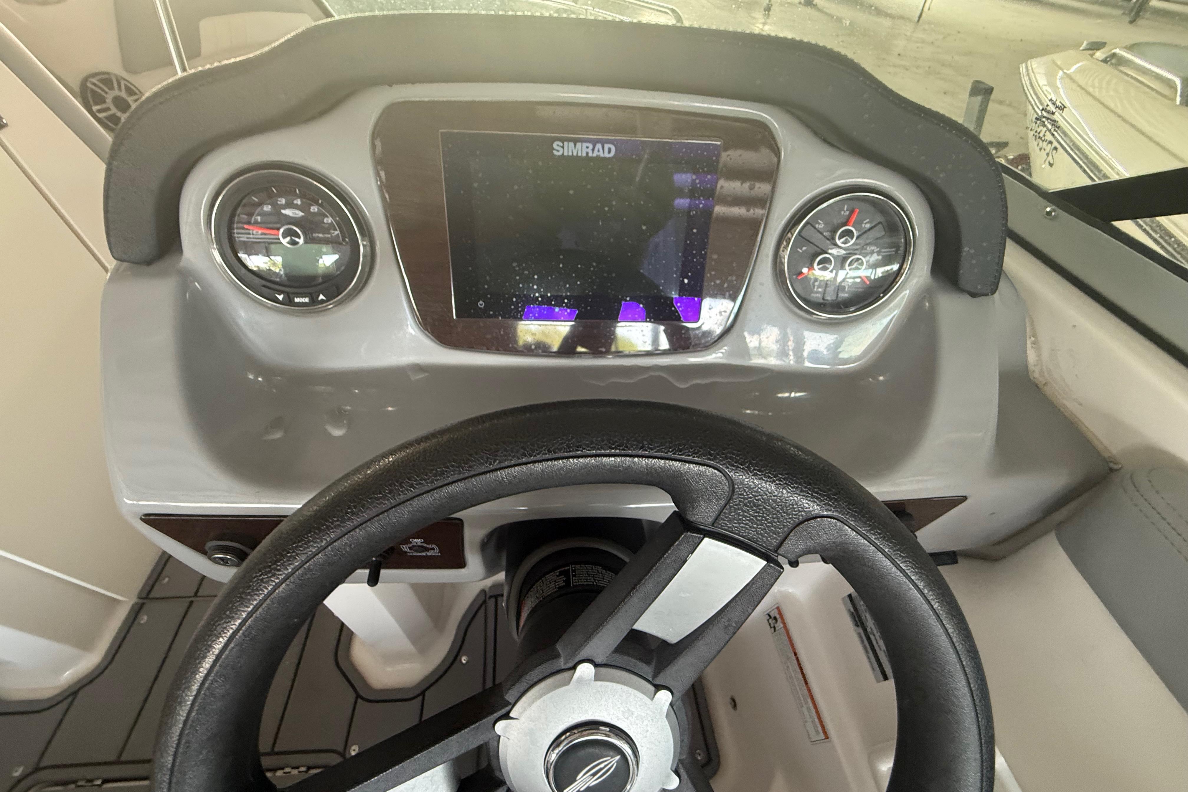 Dashboard of 2023 Chaparral 230 SSi boat with steering wheel and Simrad display.